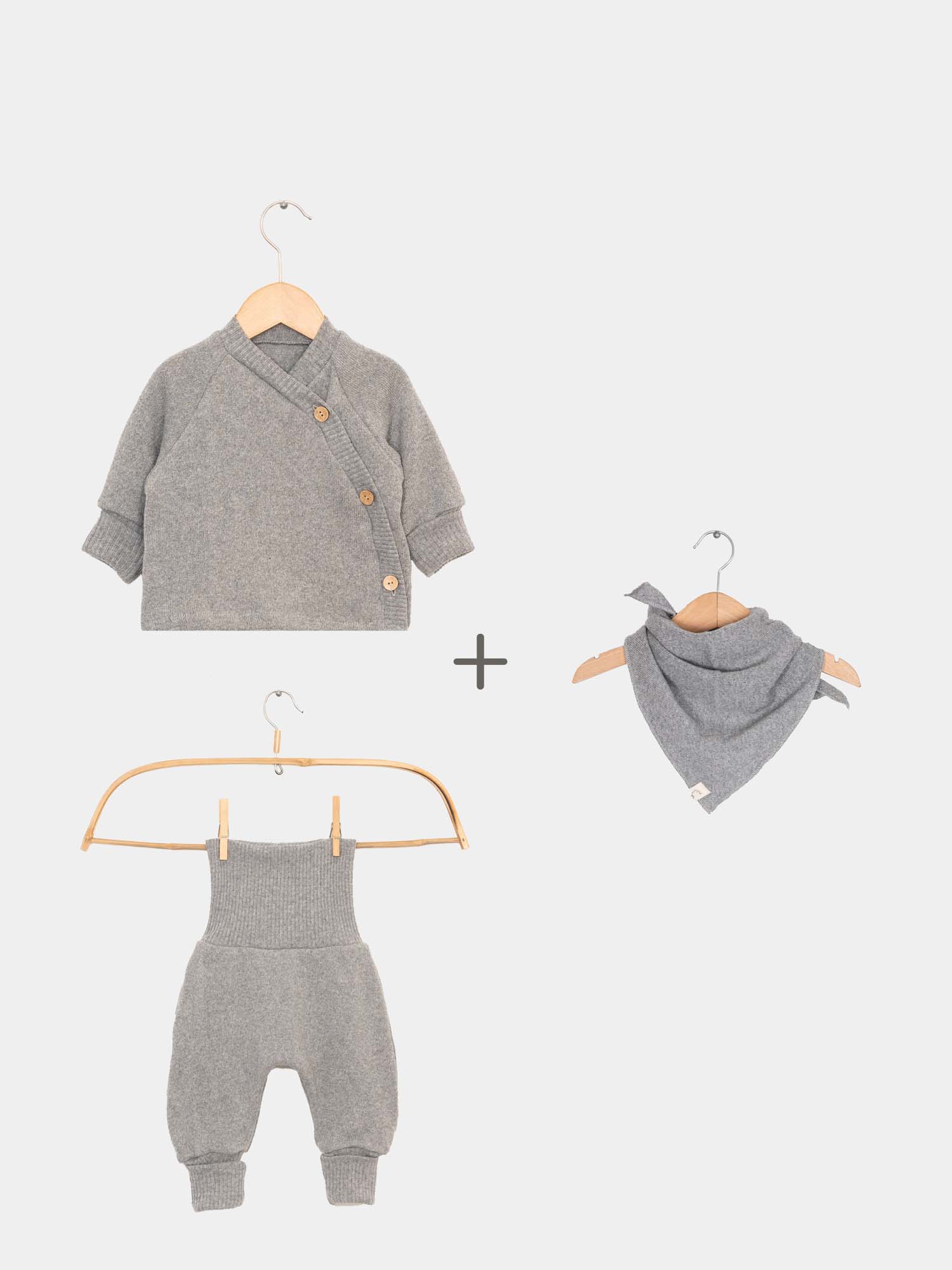 Baby Strick Set - Maus: Graues Schlüttli mit Knöpfen und passendem Tuch auf einem Kleiderbügel präsentiert. Perfekt für stilvolle Babykleidung. Perfekte Erstausstattung Baby