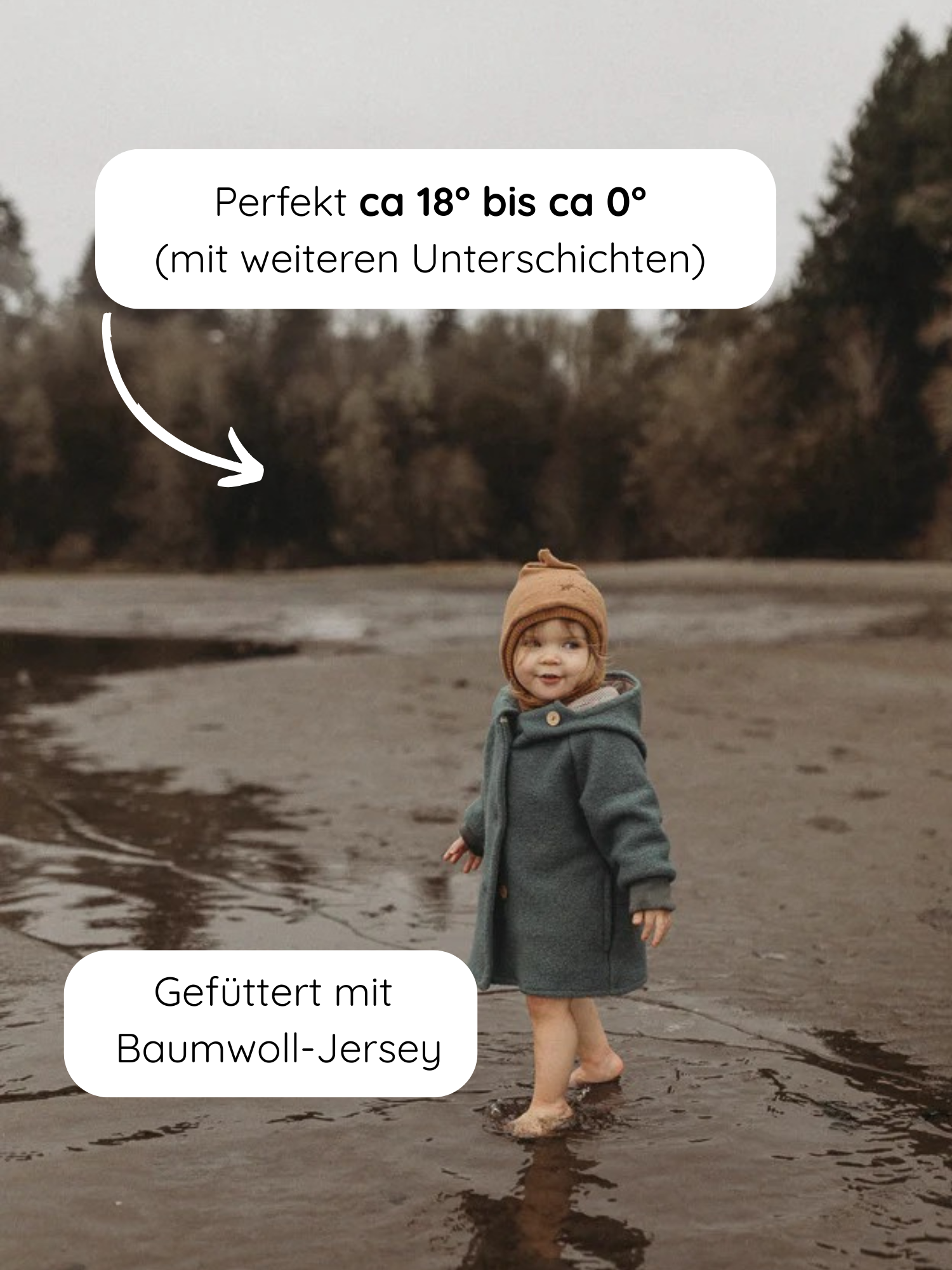 Ein Kleinkind steht barfuß im Wasser und trägt die Wichteljacke Wollwalk - Taube. Die Jacke ist warm, mit Bio-Baumwoll-Jersey gefüttert und ideal für kühlere Temperaturen.