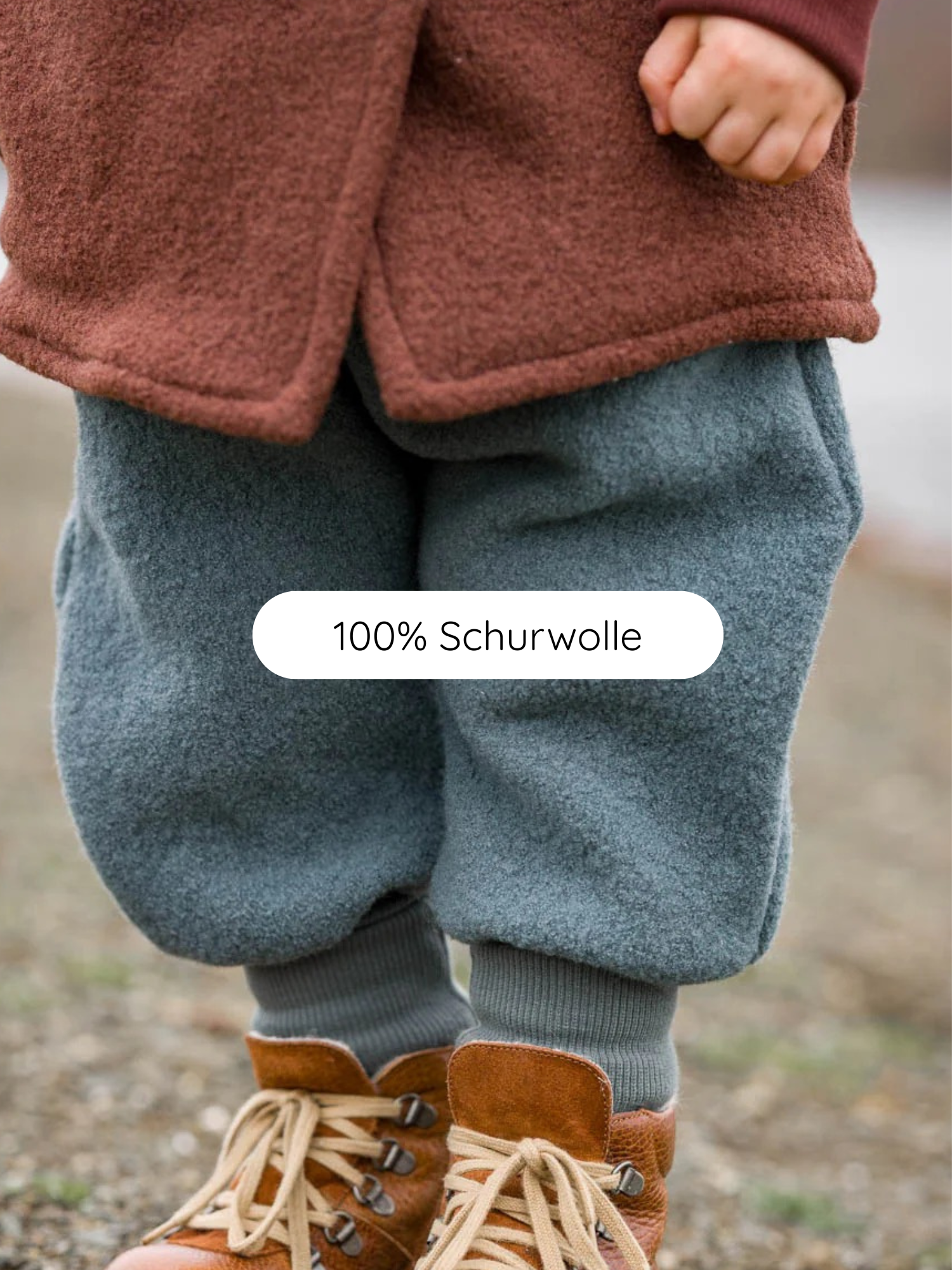 Knickerbocker Wollwalk - Taube: Ein Kind trägt eine rust-braune Wolljacke, graue Wollhose mit Kängurutaschen und braune Stiefel, ideal für kaltes, nasses Wetter; aus 100% Schurwolle.