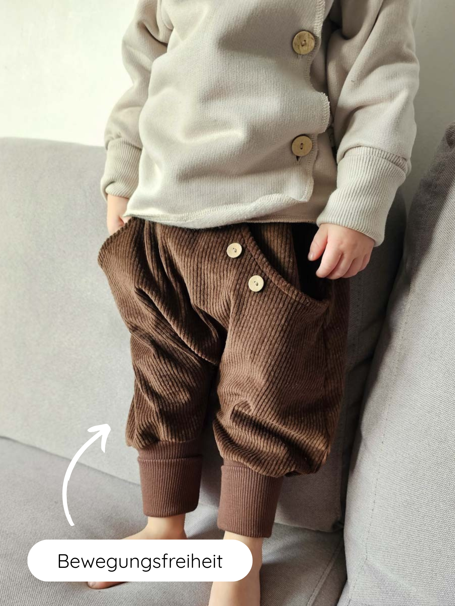 Kind zeigt Knickerbocker Breitcord - Schoko; braune Cordhose mit gerippten Bündchen und Holzknoöpfen, bietet Bewegungsfreiheit. Perfekt für alltägliches Tragen, robust und bequem. Ideal für Kinderaktivitäten.