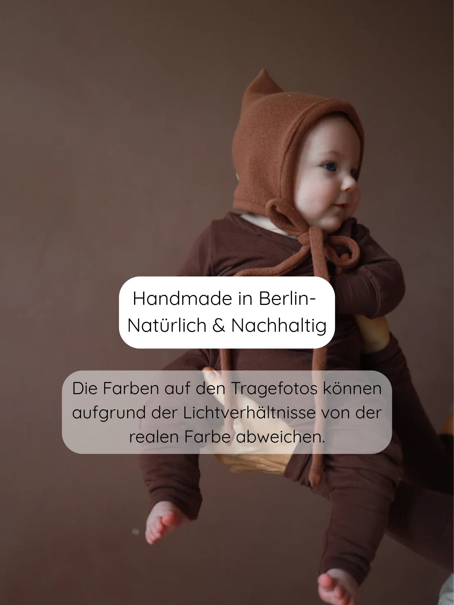 Babyknicker Bambusviskose Zartbitter: Ein Baby trägt ein erdfarbenes, gestricktes Set mit spitzer Mütze. Das Outfit ist weich und atmungsaktiv, handgefertigt in Berlin, nachhaltig und bequem für alltägliche Abenteuer.