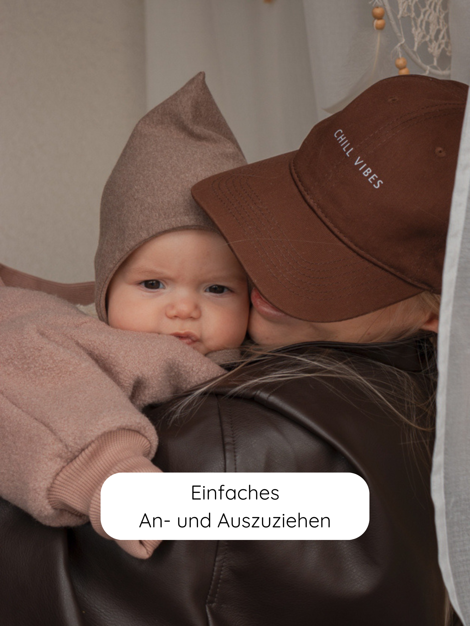 Winter Wollwalk Overall mit Teddyfutter- Puder: Ein Baby im Overall mit Teddyfutter wird gehalten. Der Overall ist bequem anzuziehen und ideal für kalte Tage dank atmungsaktiver Naturmaterialien.
