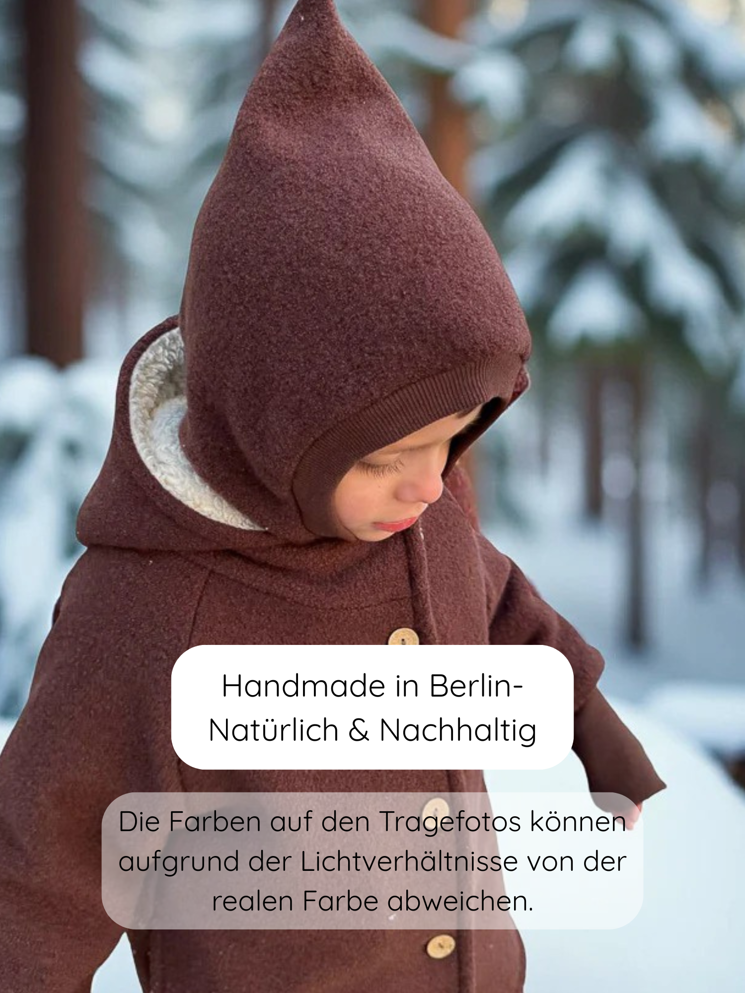Kleinkind im Schnee trägt eine Schlupfmütze Wollwalk - Schoko mit spitzer Kapuze und Knopfverschluss, betont durch handgefertigte Verarbeitung aus Berlin für nachhaltigen Kälteschutz.