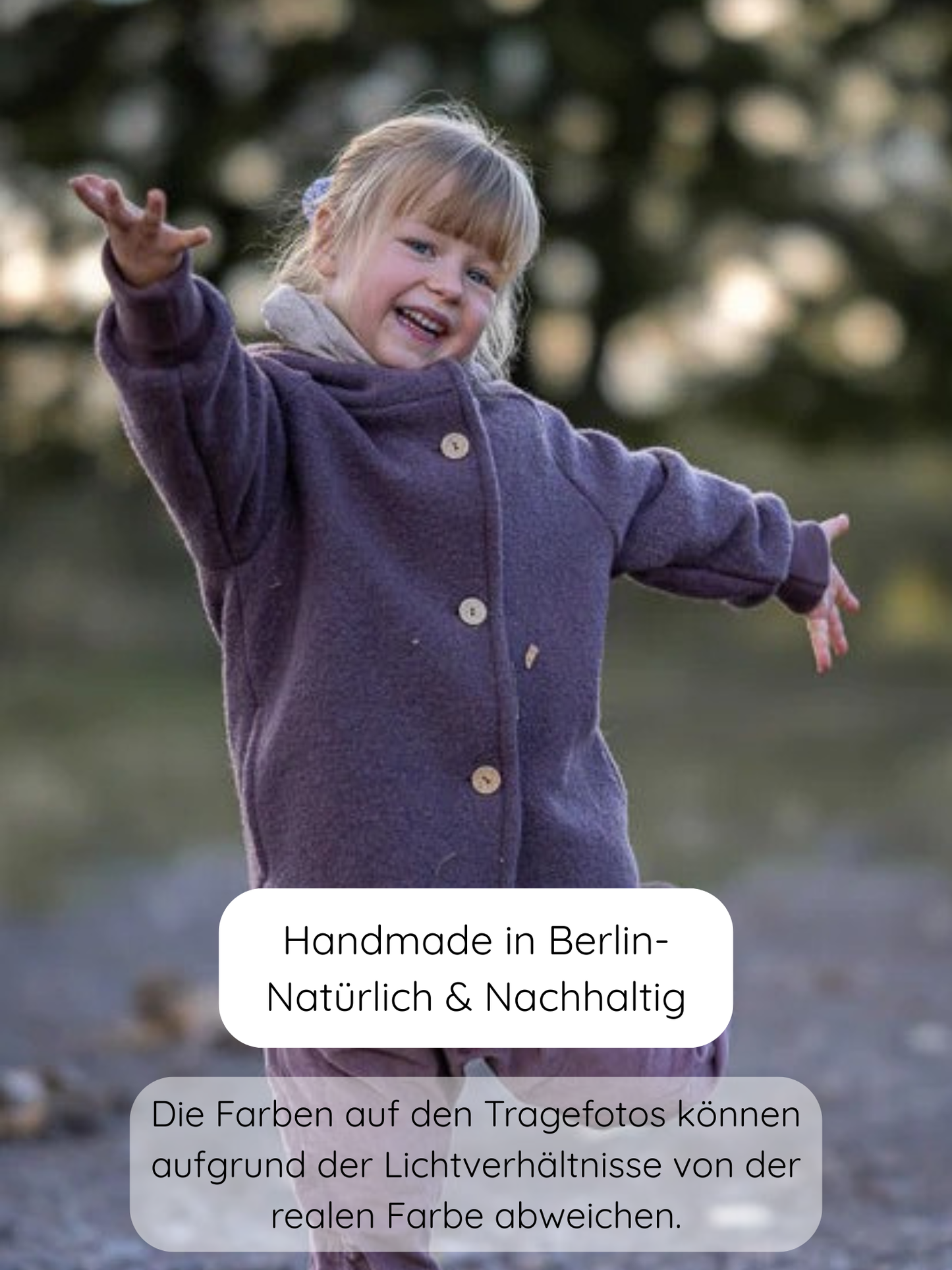 Junges Mädchen im Freien, lächelnd mit ausgestreckten Armen, trägt die Wichteljacke Wollwalk - Malve. Die lila Jacke hat einen Knopfverschluss und ist perfekt für kühle Jahreszeiten.