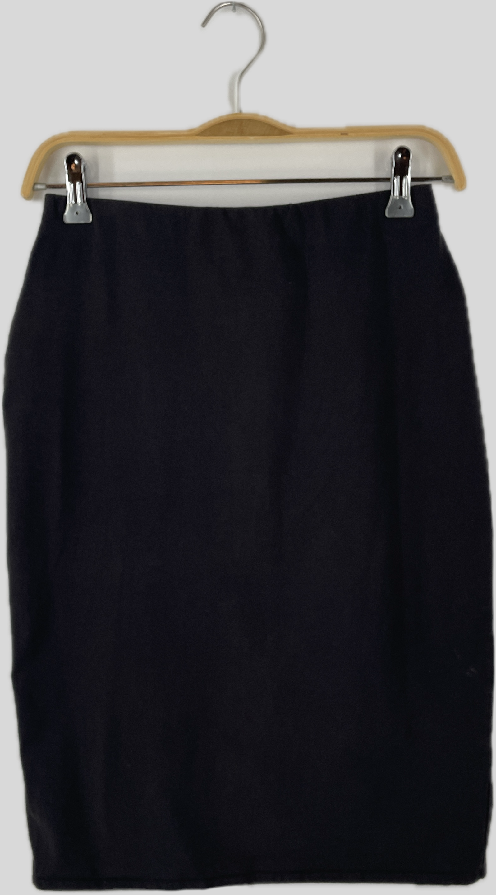 Frauen Bleistiftrock Jersey Ruß Gr. S: Ein schlichter, schwarzer Rock im Bleistiftschnitt mit Bund an einem Holzbügel. Der Rock hat einen Schlitz hinten und zeigt vorne einen Fleck. Zustand: gut.