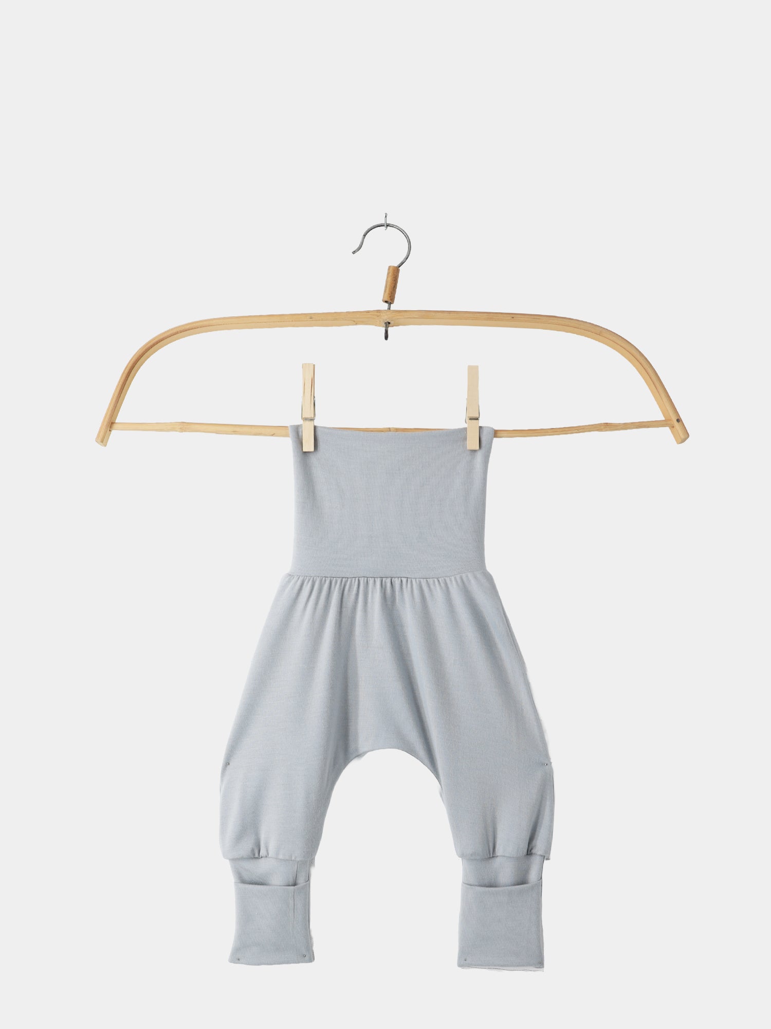 Babyknicker Bambusviskose Eisblau auf Holzbügel: ein lockerer, grauer, tiefgeschnittener Babystrampler aus weicher, atmungsaktiver Bambusviskose, ideal für Bewegungsfreiheit und Komfort.