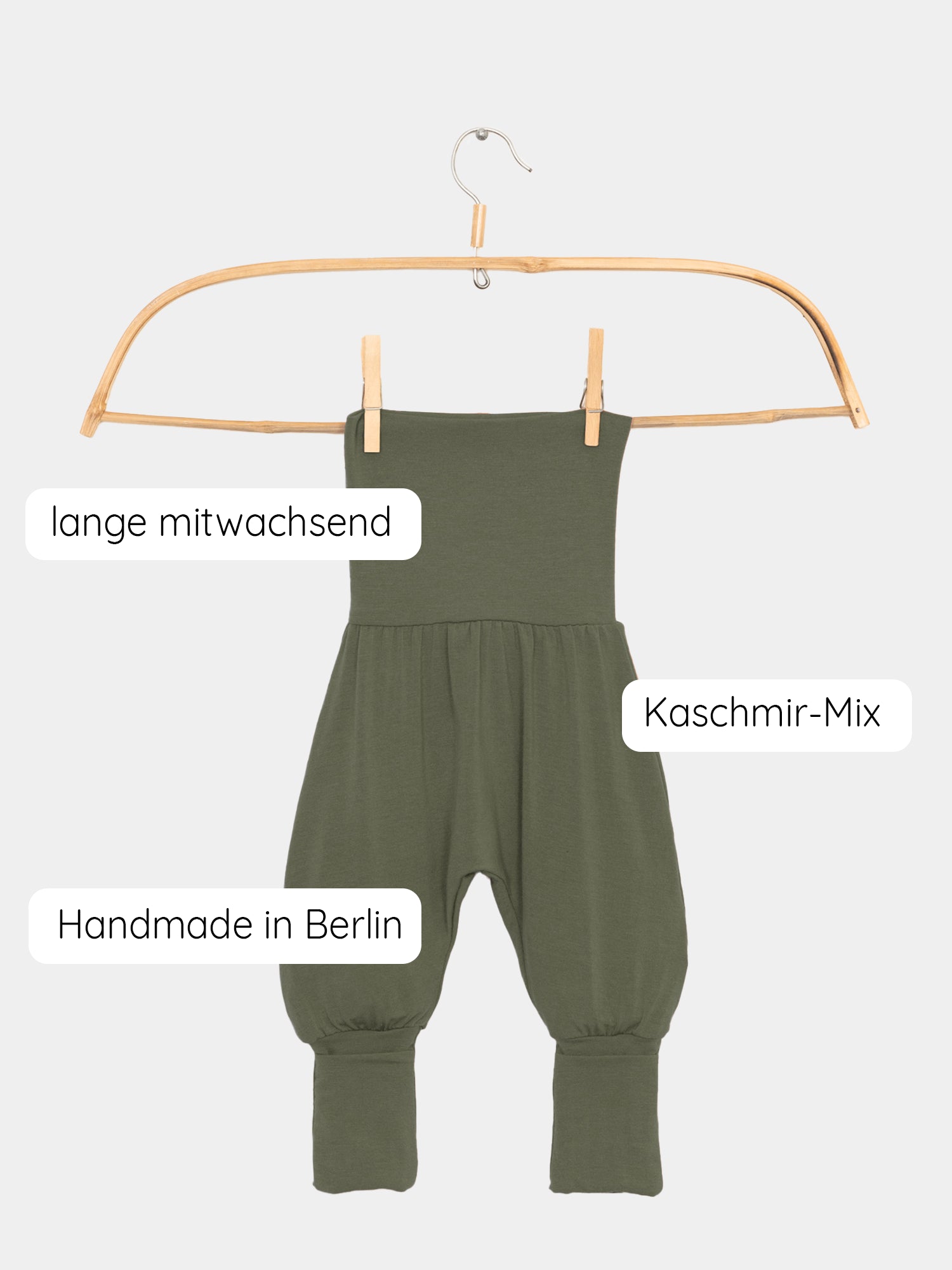Babyknicker Kaschmir-Mix - Avocado auf einer Schaukel, mit Klappbündchen sichtbar. Logo-Detail und Schrift auf der Hose erkennbar, perfekt kombinierbar mit dem Loopbody für Neugeborene. Erstausstattung Baby und Geschenk für Babys.