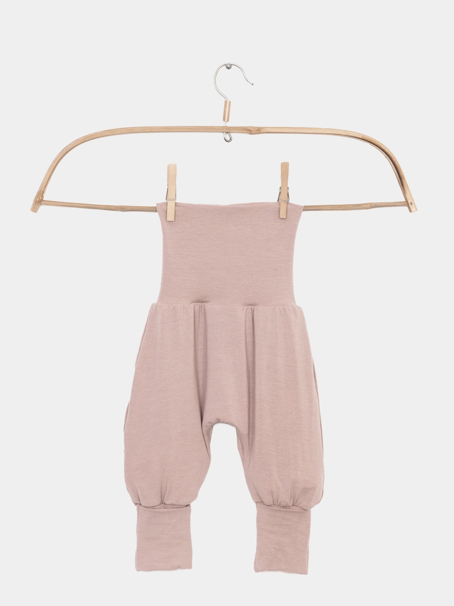 Babyknicker Kaschmir-Mix - Puder: Harem-Babyhose mit hohem, elastischem Bund und gerafften Knöcheln, aufgehängt an einem einfachen Holz-/Bambuskleiderbügel. Ideal für weiche und wärmende Erstausstattung.