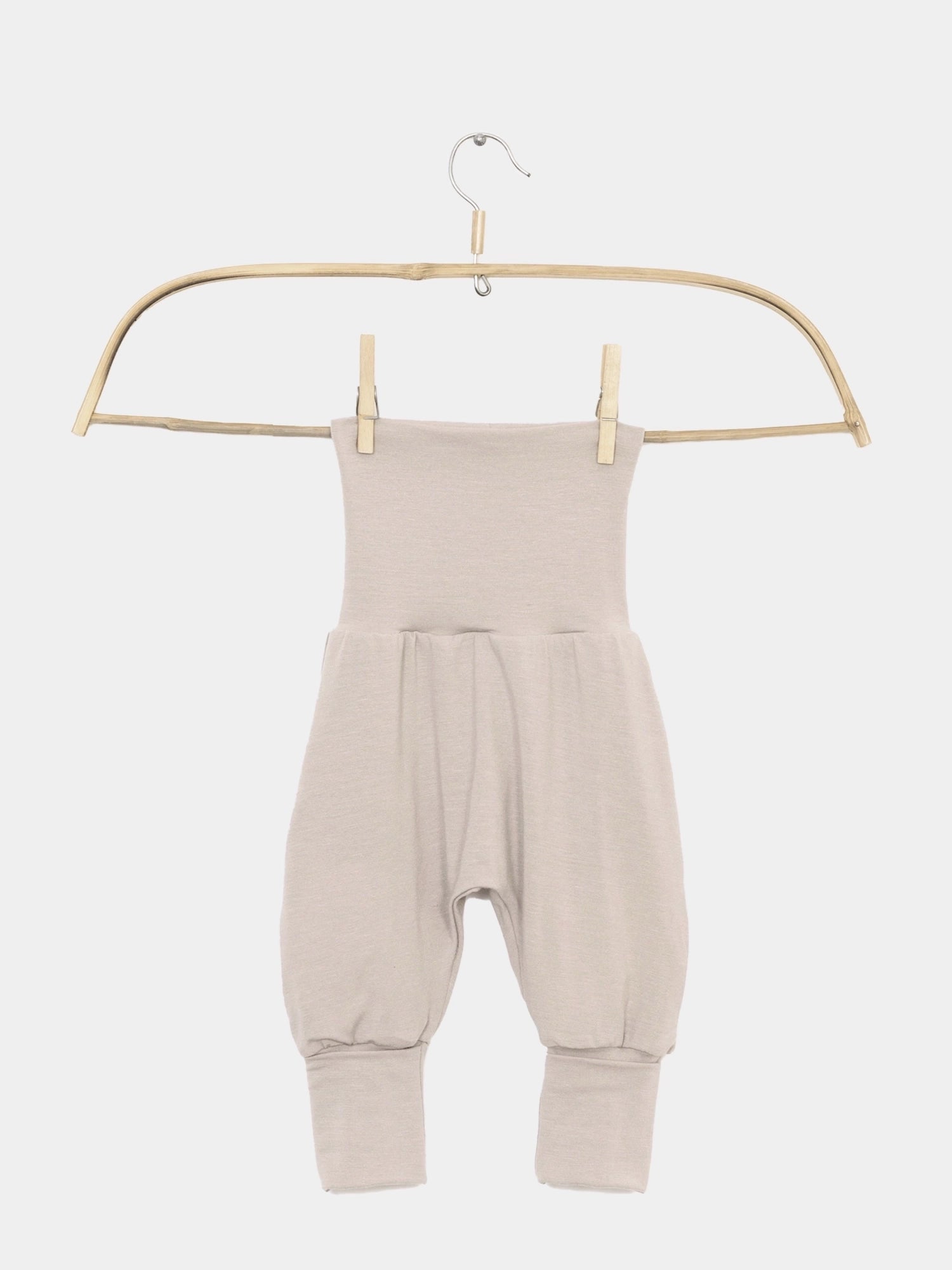 Babyknicker Kaschmir-Mix - Sand: Leicht-beige Haremshose für Babys mit hohem Klappbund und umgeschlagenen Knöcheln, aus weichem Kaschmir-Mix, ideal für zarte Babyhaut, auf einem Holzbügel aufgehängt.