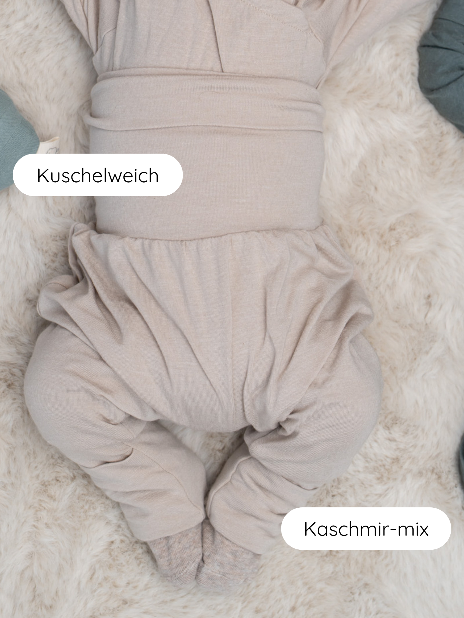 Babyknicker Kaschmir-Mix - Sand: Unterer Teil eines Babys in einem weichen, beigefarbenen Jumpsuit auf flauschigem Teppich, mit Klappbündchen für wärmende Anpassung und sanft zur Babyhaut.
