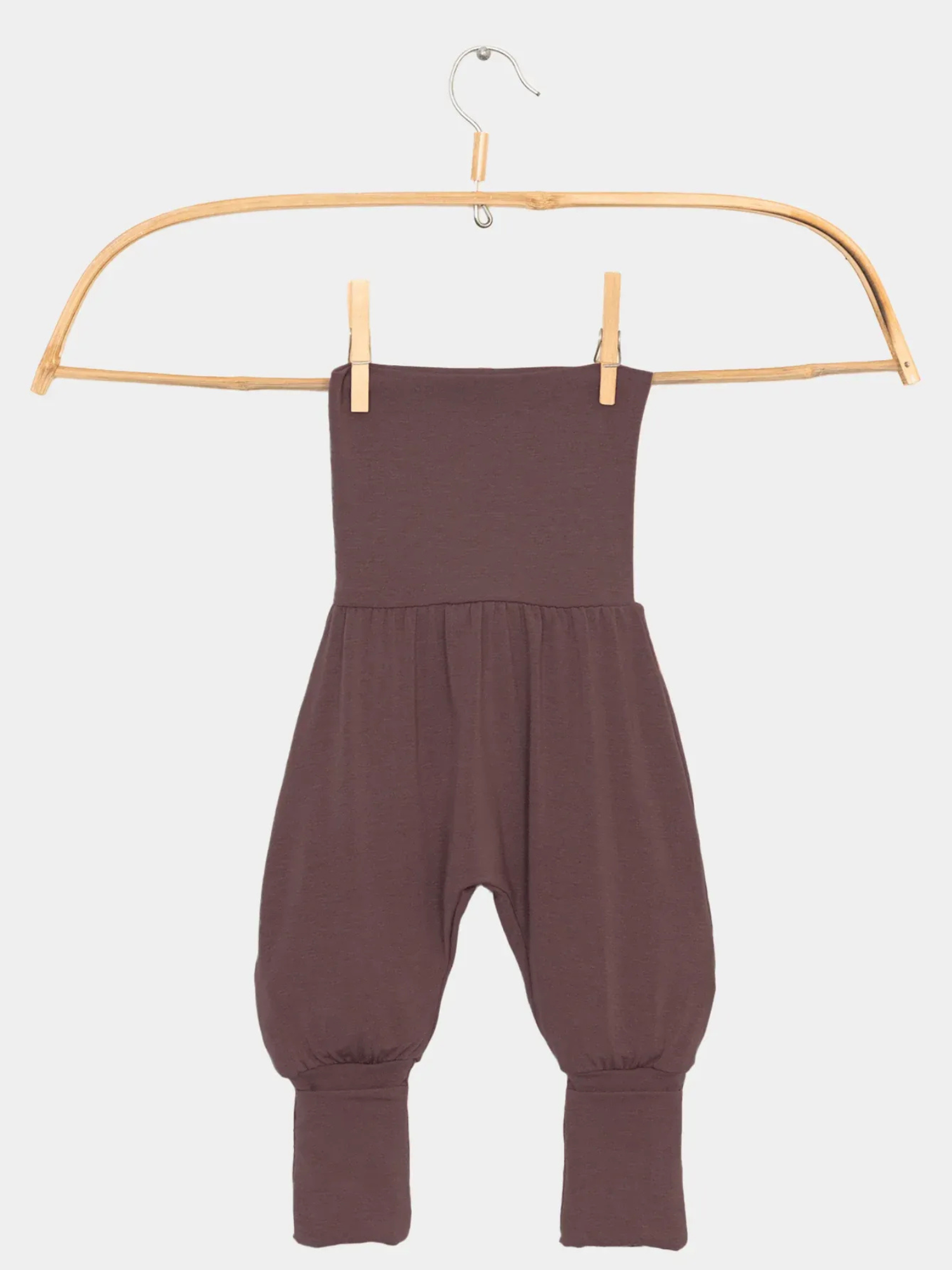 Babyknicker Kaschmir-Mix - Malve: Strapless brauner Strick-Romper mit hohem Klappbund und gerafften Beinen, die in Bündchen auslaufen, auf einem Holzkleiderbügel vor weißem Hintergrund präsentiert.