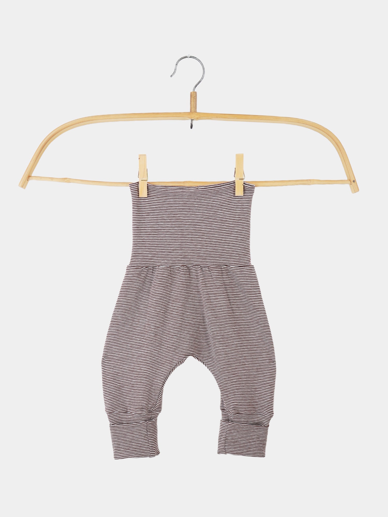 Babyknicker Bio-Baumwolle - Schoko Ringel, nahaufnahme zeigt weiche, atmungsaktive Streifenhose auf einem Haken mit Holzgriff, betont Bewegungsfreiheit und Komfort für zarte Babyhaut, nachhaltig hergestellt in Berlin.