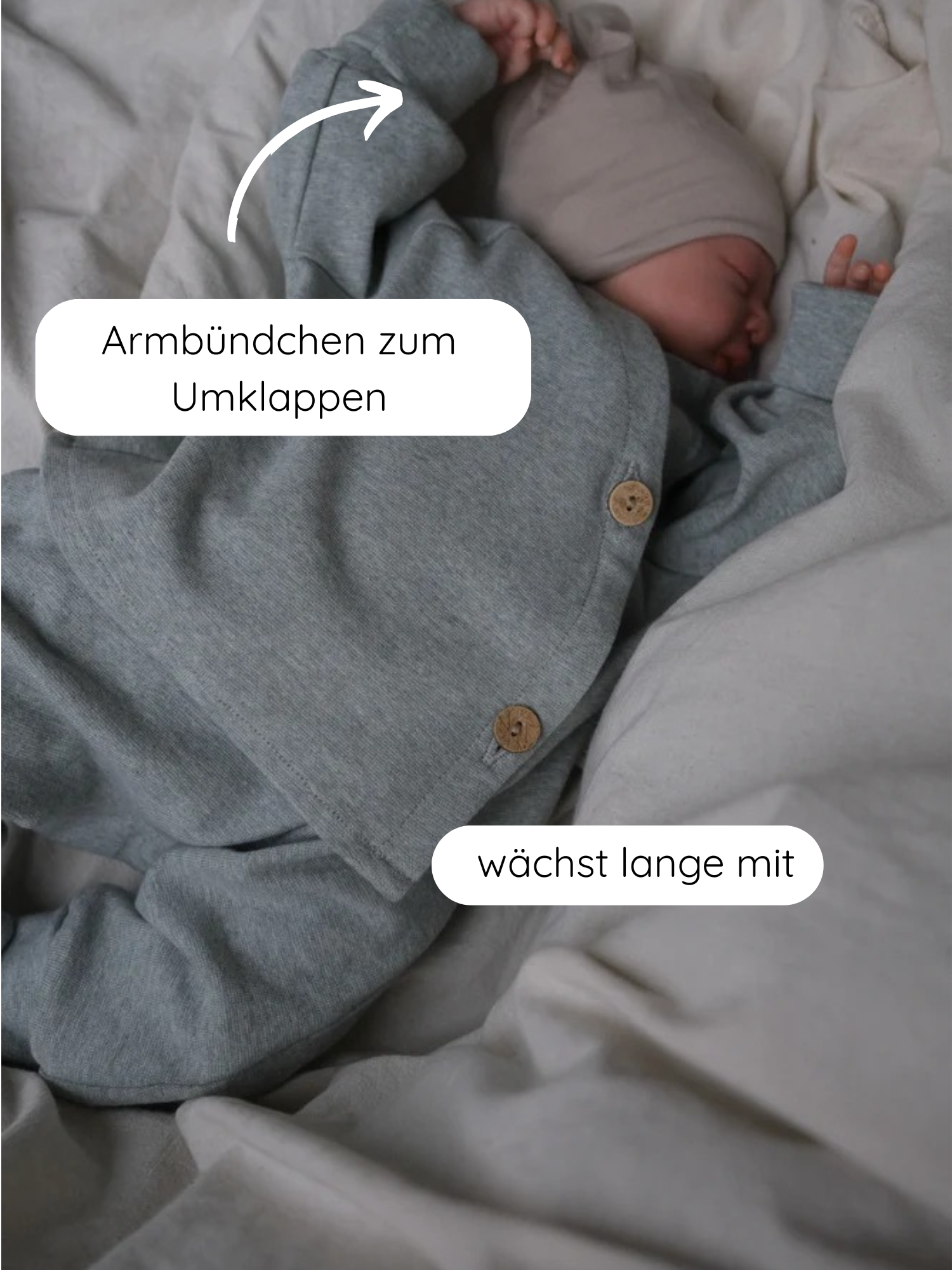 Neugeborenes schläft in Babyschlüttli Feinstrick - Mint Meliert: weiches, meliertes Feinstrick-Jersey-Outfit mit Wickelverschluss, Holzknöpfen, umklappbaren Armbündchen. Nachhaltig gefertigt, bietet es Komfort und Bewegungsfreiheit.