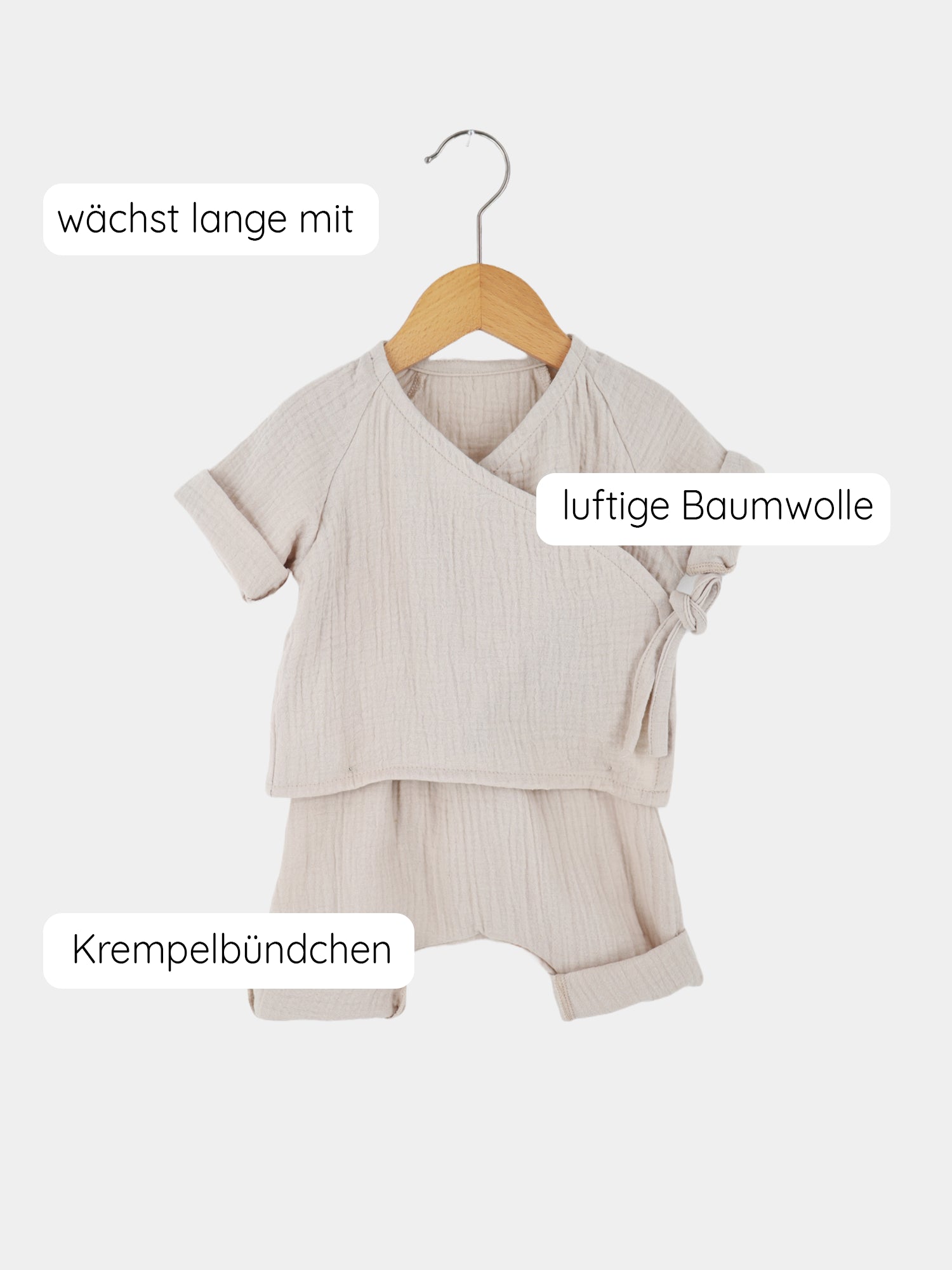 Babyset Baumwoll-Musselin - Sand auf einem Kleiderbügel, bestehend aus einem Wickel-Schlüttli mit seitlicher Schleife und weiten Hosenbeinen, ideal für empfindliche Babyhaut, handgemacht in Berlin.