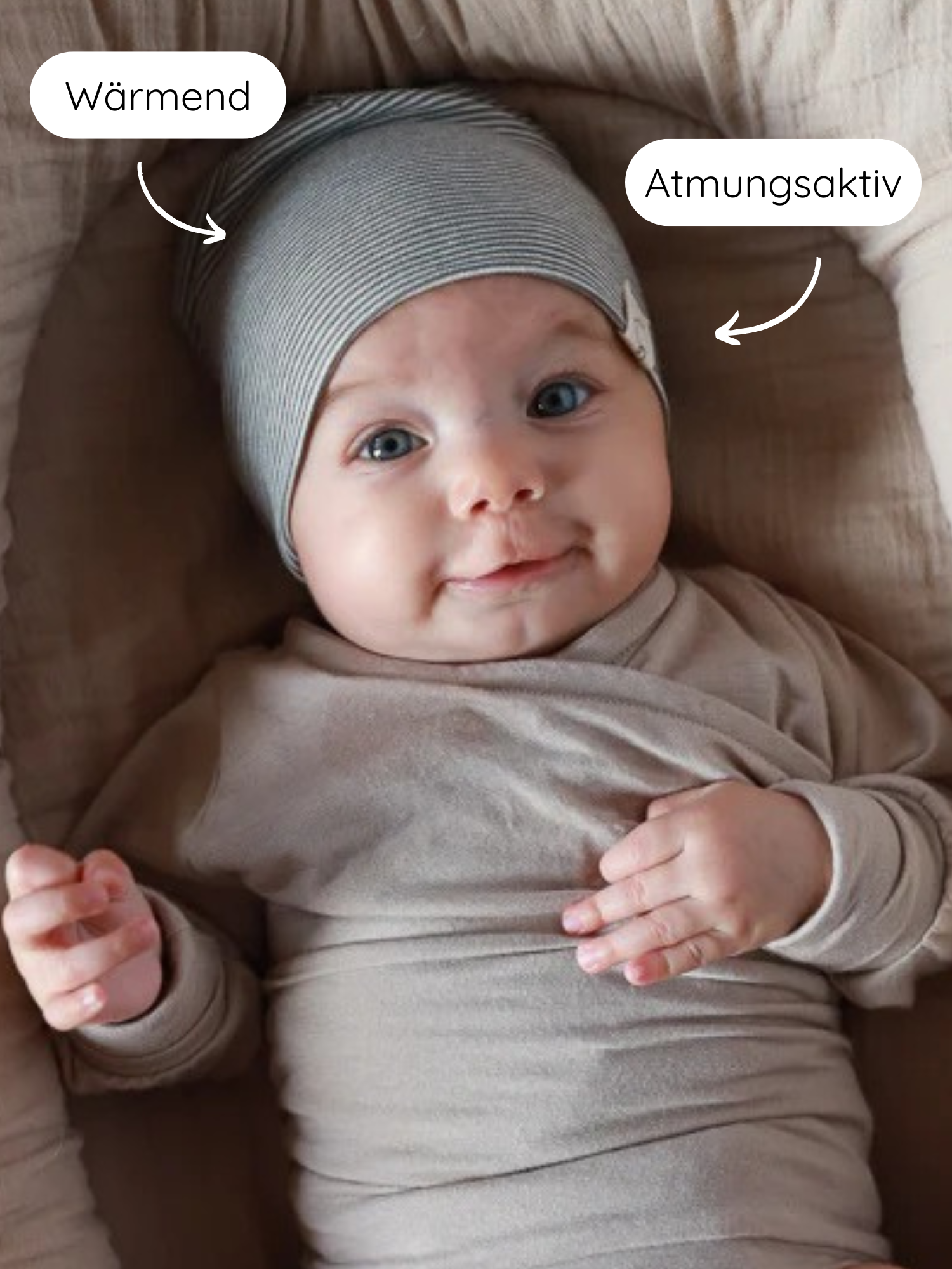 Beanie Bio-Baumwolle - Ringel Maus: Ein Baby ist in einem weichen, neutralen Outfit eingewickelt, trägt eine gestreifte Mütze, die als wärmend und atmungsaktiv in den Callouts hervorgehoben wird.