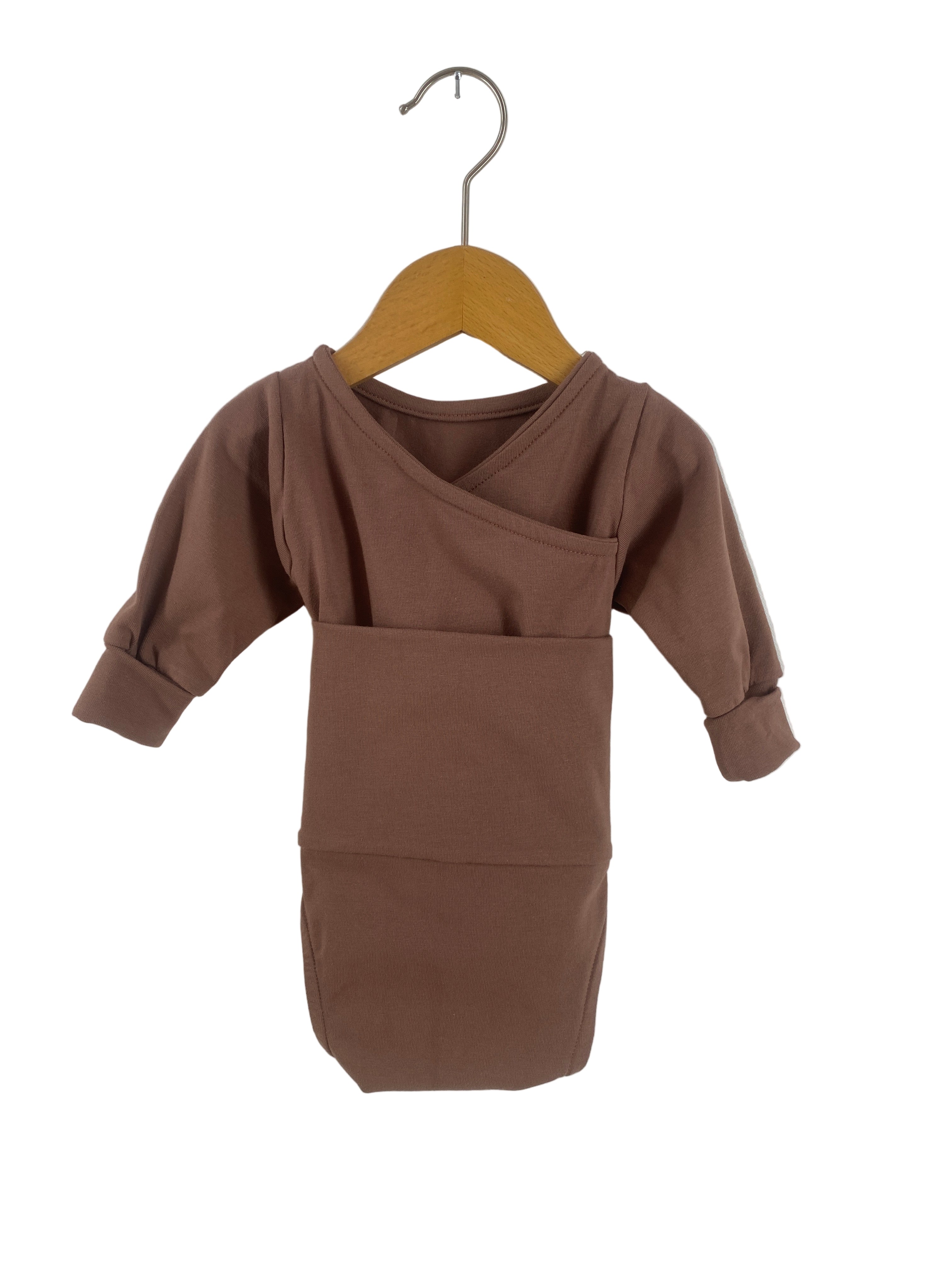 Kopie Loopbody Baumwoll-Jersey hellbraun Gr 0M: Ein schlichter langärmeliger Baby-Body im Kimono-Stil mit überkreuztem V-Ausschnitt, aufrollbaren Ärmeln und gerafftem Saum, präsentiert auf einem Holzkleiderbügel.