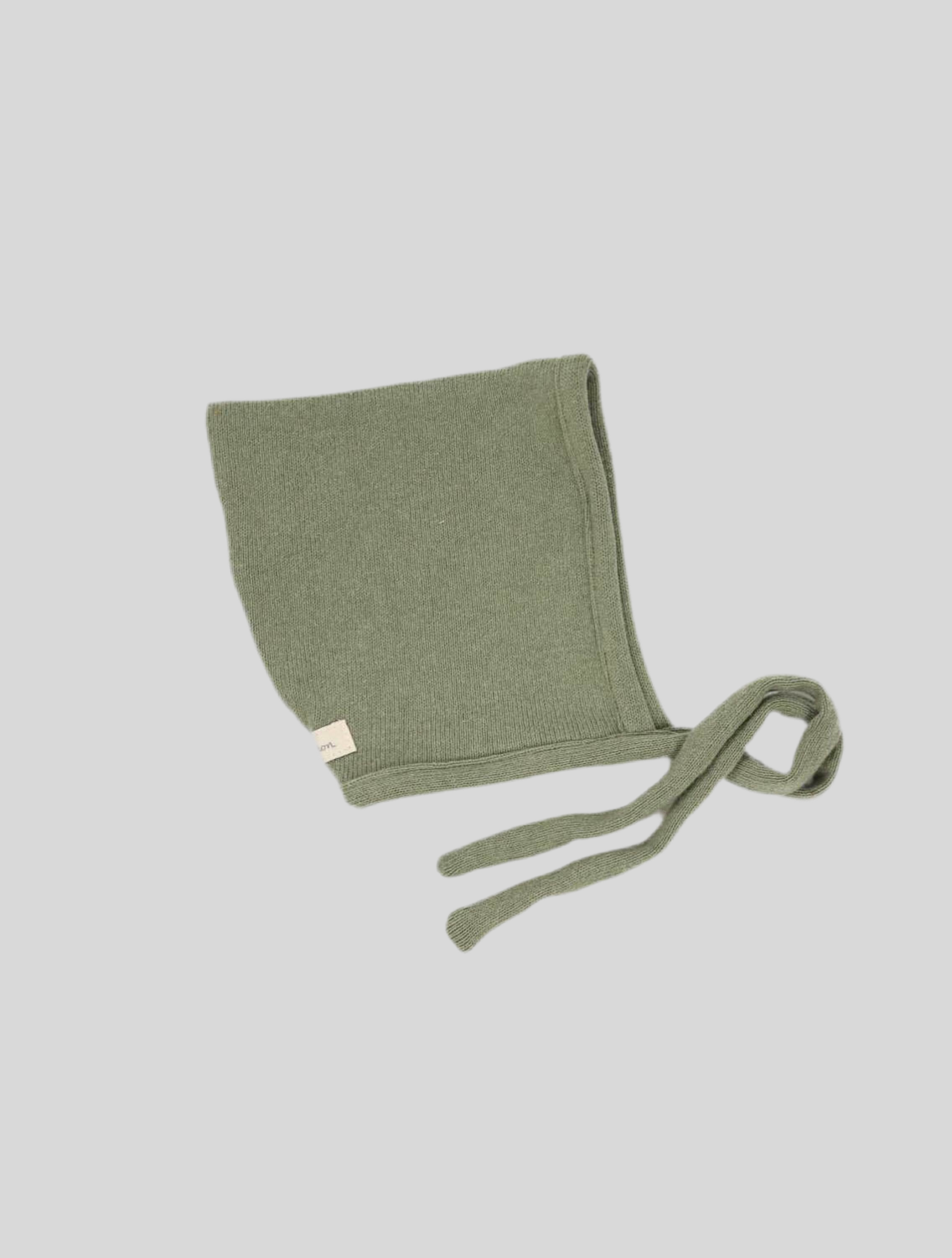 Zwergenmütze Bio-Strick Salbei Gr.6M, grüne Strickmütze mit Bindebändern, nah aufgenommen. Zeigt feine Strickdetails und ein kleines weißes Etikett. Zustand: sehr gut.