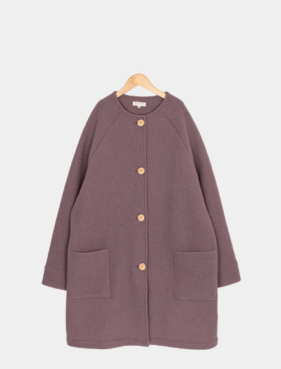 Damenmantel Wollwalk Malve Gr XL, ein langes, oversized Wollmischungs-Kleidungsstück mit Rundhalsausschnitt, Raglanärmeln, vier großen Holzknöpfen und zwei aufgesetzten Taschen, hängt an einem hölzernen Bügel. Zustand: neu.