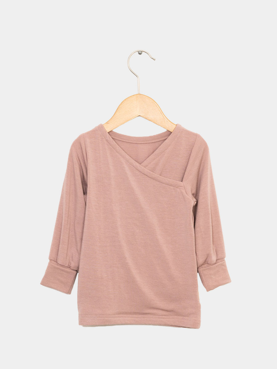 NEU Wickelshirt Kaschmir-Mix Puder Gr 6M, präsentiert auf einem Kleiderbügel. Das Wickelshirt hat einen V-Ausschnitt und ist aus weichem Stoff gefertigt, ideal für lässigen Stil.
