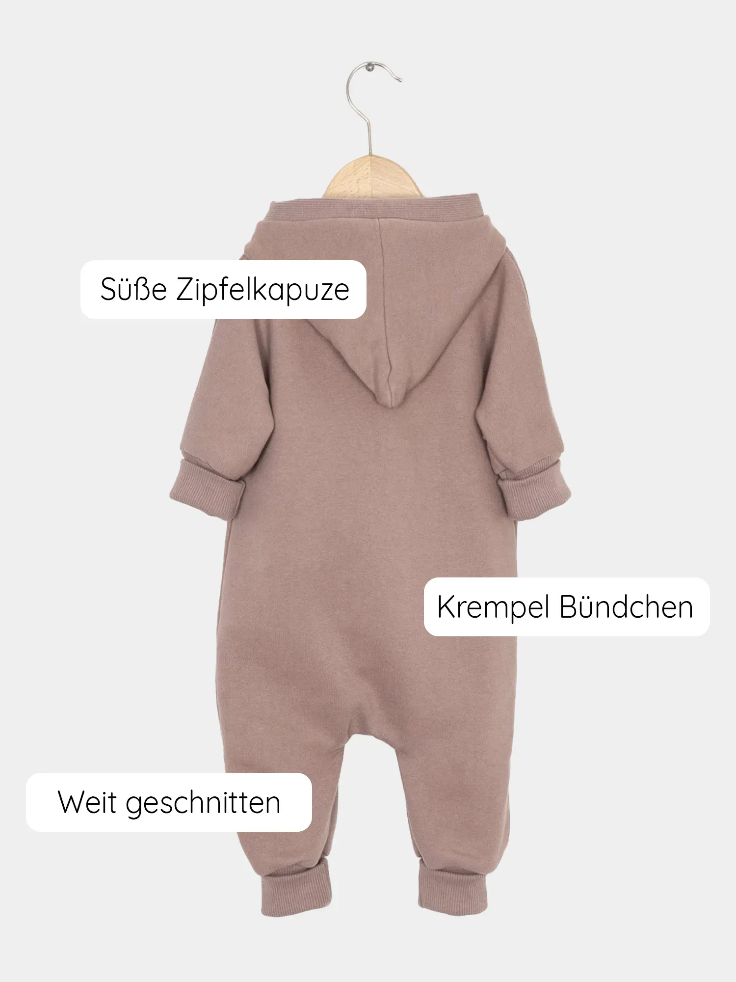 Kuschelanzug Bio-Sweat - Puder: Ein weicher, locker geschnittener Baby-Overall mit süßer Zipfelkapuze, krempelbaren Bündchen und schräger Knopfleiste, präsentiert auf einem Holzbügel. Perfekt für Übergangszeiten.