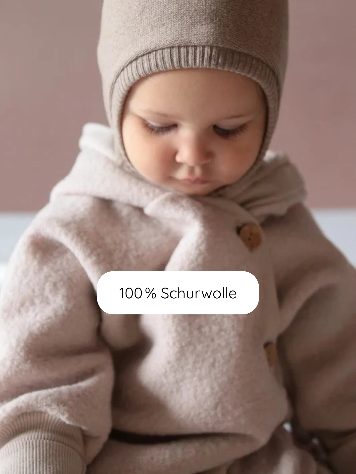 Kleines Kind im Kuschelanzug Wollwalk - Sand, bestehend aus 100 % Schurwolle, mit Kapuze und passender Strickmütze. Textoverlay: 100 % Schurwolle.
