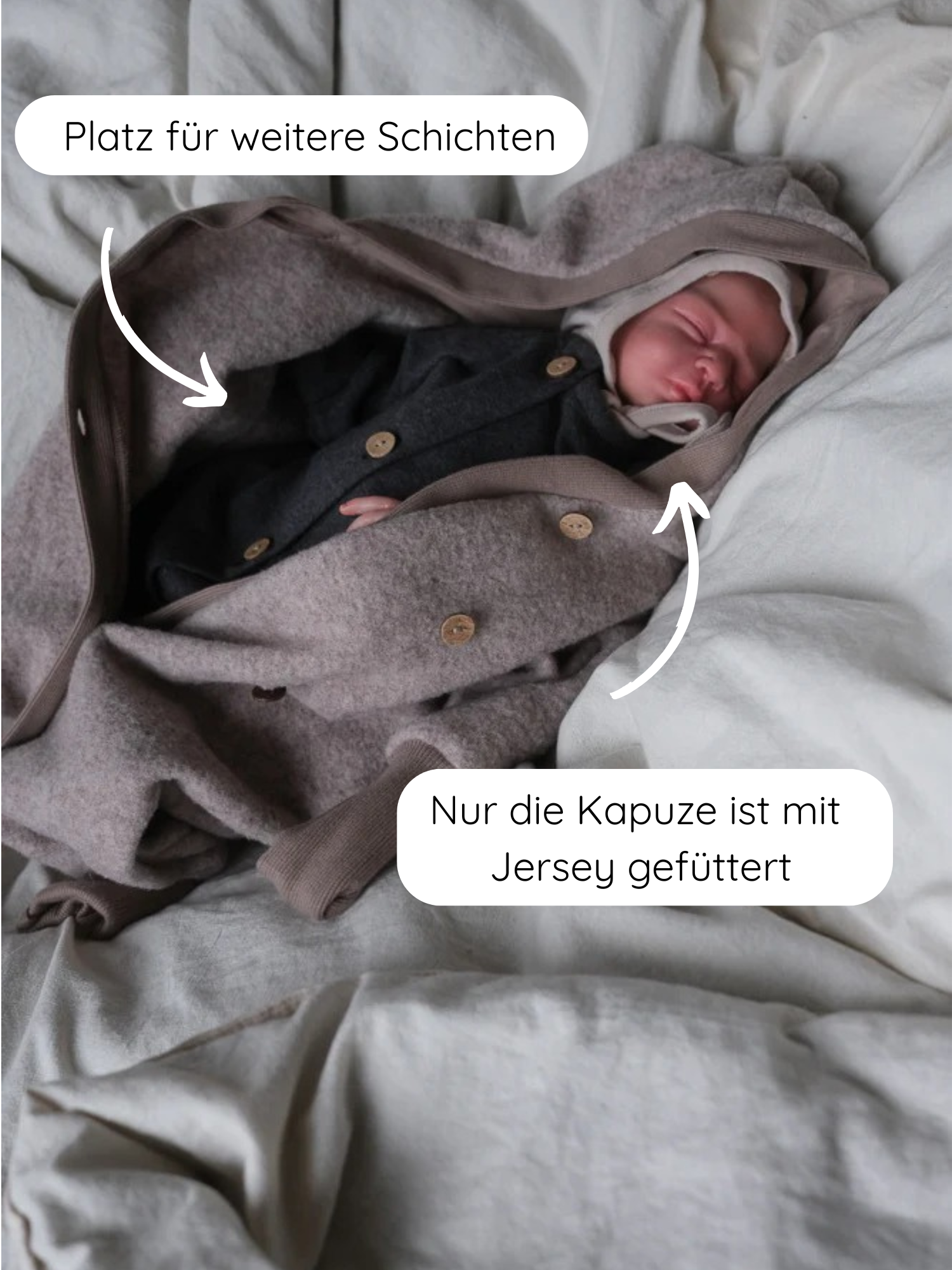 Kuschelanzug Merino Wollfleece - Hafer: Ein Baby liegt in einem Merino-Wollfleece Overall mit Kapuze, die mit Jersey gefüttert ist. Der Overall bietet Platz für weitere Schichten, ideal für kühle Tage.