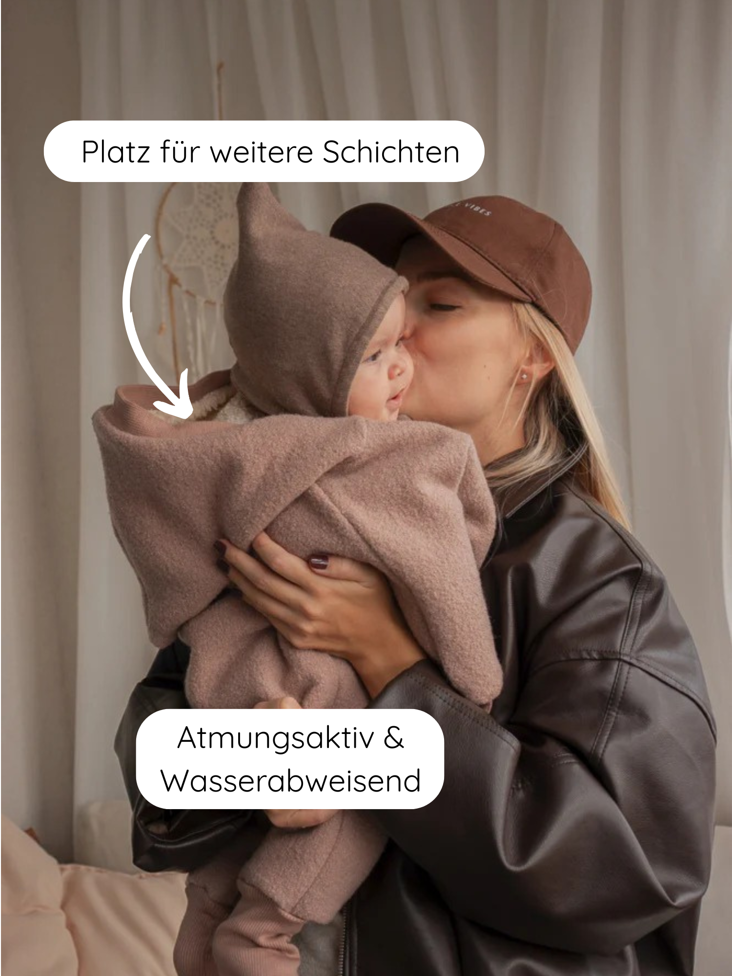 Junge Mutter küsst Säugling im taupefarbenen Winter Wollwalk Overall mit Teddyfutter-Puder. Der Overall ist atmungsaktiv, wasserabweisend und bietet Platz für weitere Schichten, ideal für kalte Tage.