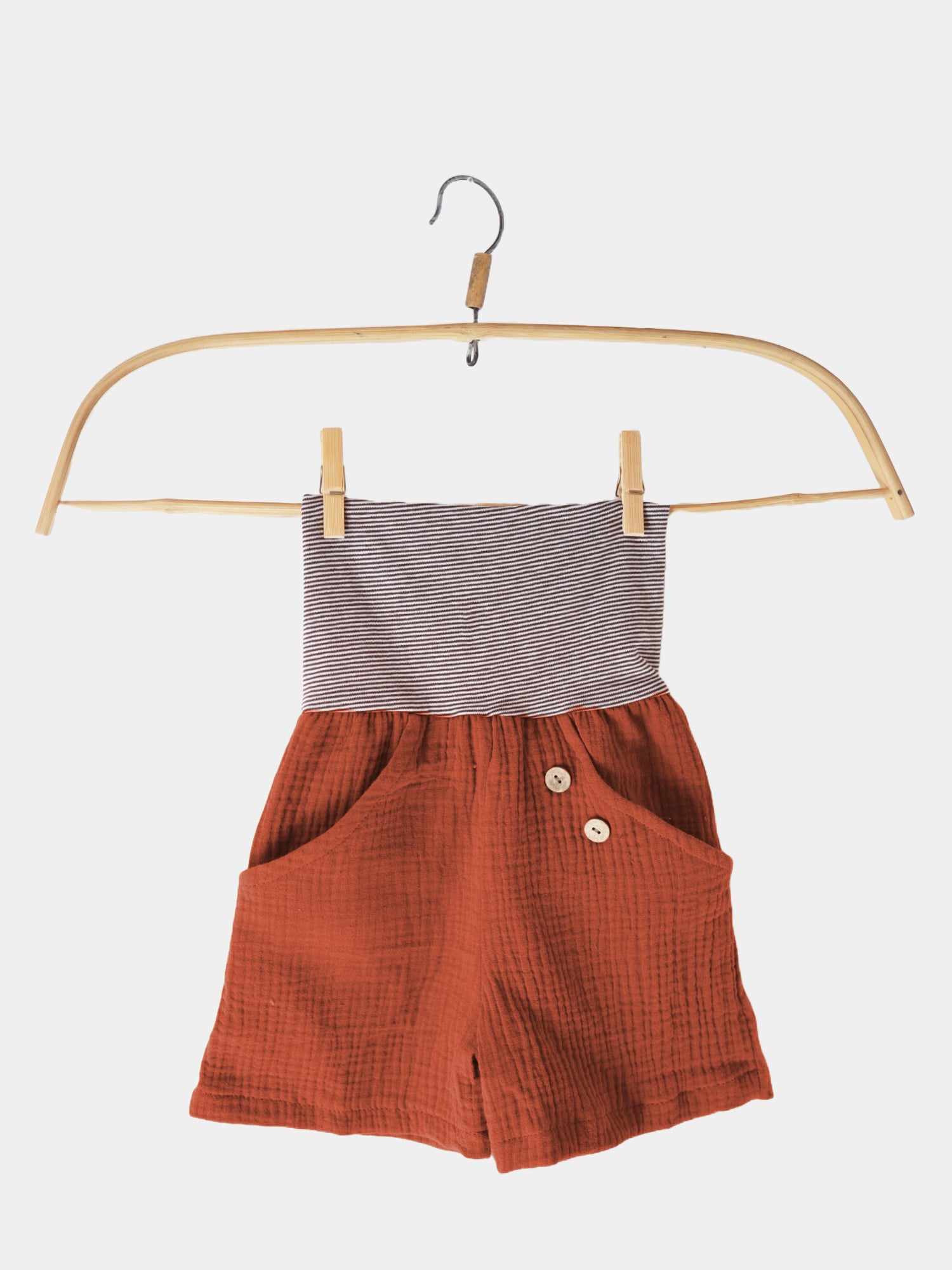 Kurze Buxe Musselin - Terracotta: Shorts aus 100% Baumwoll-Musselin mit Ringelbündchen, auf einem Kleiderbügel präsentiert. Nachhaltig in Berlin gefertigt, ideal für den Sommer.
