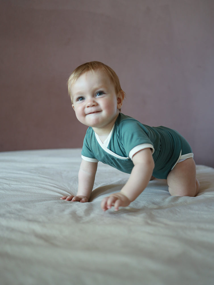 Kurzarm Loopbody Bambusviskose - Türkis: Ein babyfreundlicher, knopflose Body aus weichem, elastischem Bambus, ideal für Sommer, mit einzigartigem Loopdesign für einfaches An- und Ausziehen.