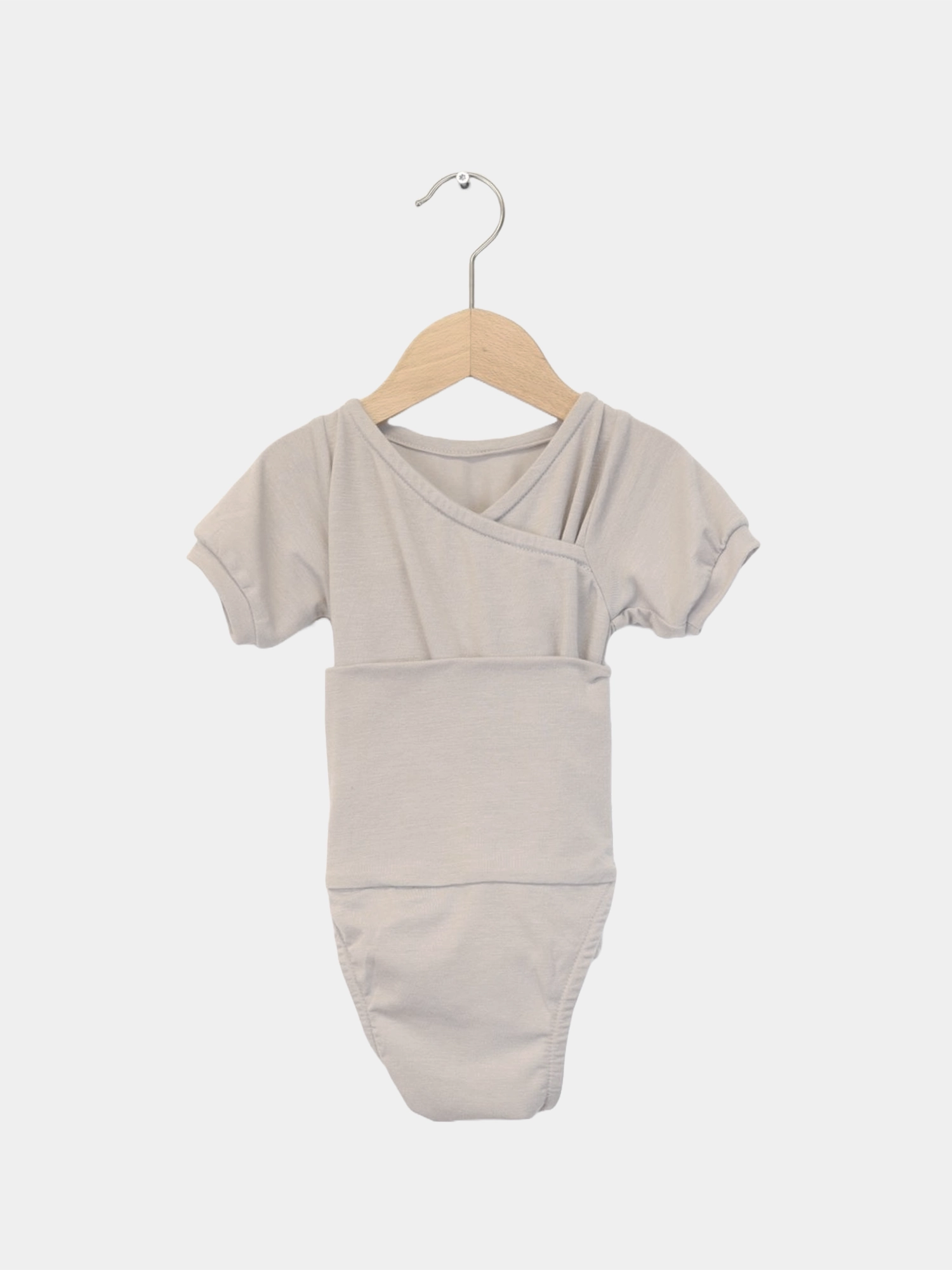 Kurzarm Loopbody Kaschmir-Mix - mitwachsender Babybody auf einem Holzkleiderbügel, besonders weich und ohne Knöpfe, ideal für einfachen Wechsel und Komfort. Perfekte Baby Geschenke.