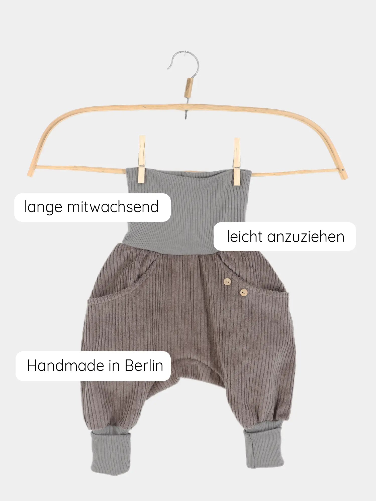 Knickerbocker Breitcord - Praline: Kinderharemshose aus weichem Breitcord mit geripptem Bund und Knöchelbündchen, verziert mit Holzknöpfen an der Tasche. Text overlay: „lange mitwachsend“, „leicht anzuziehen“, „Handmade in Berlin“.
