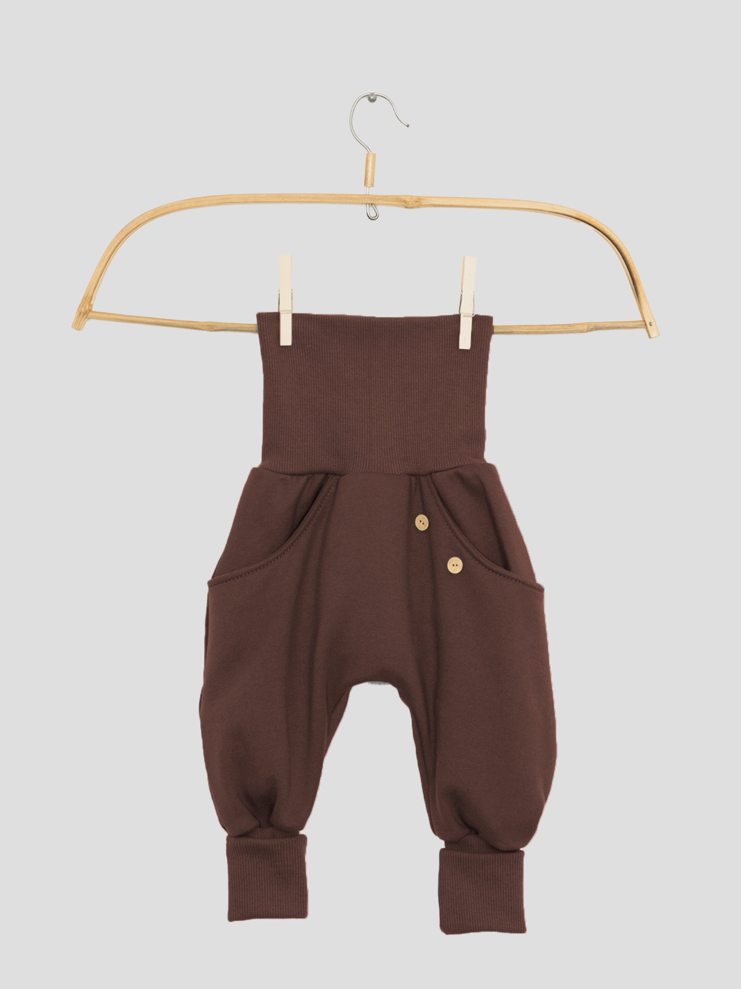 Nahaufnahme der Knickerbocker Bio-Sweat - Schoko mit durchgehender Kängurutasche, klassischen PETIT COCHON Schnitt und Krempelbündchen, die Bewegungsfreiheit bieten. Kombiniert perfekt mit Schlüttli Bio-Sweat.