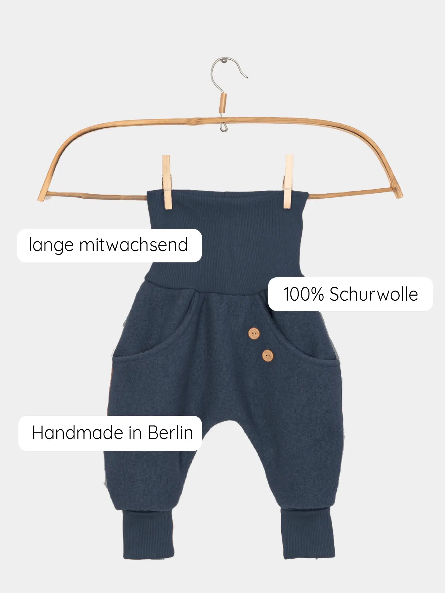 Knickerbocker Wollwalk - Marine: Kinderhosen aus 100 % Schurwolle, hängend an einem Holzbügel, mit Kängurutaschen, zwei Holzknöpfen, breiten Bündchen und handgefertigt in Berlin.