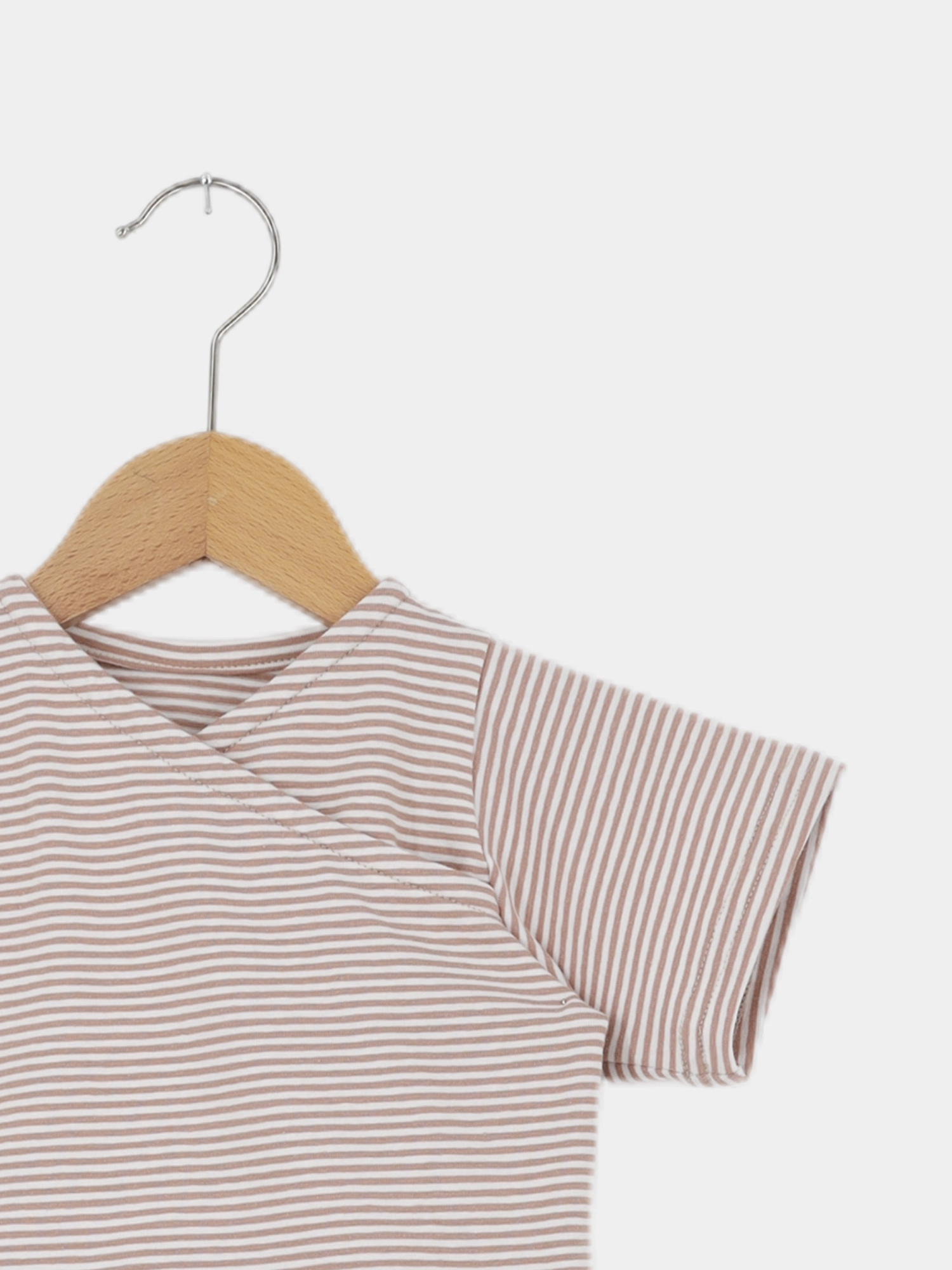 Kurzarm-Shirt Wickel Overall Baumwolle - Ringel Weizen, beige-weiß gestreift, hängt auf Holz-Kleiderbügel vor weißem Hintergrund. Lockerer Schnitt bietet Bewegungsfreiheit. Ideal für warme Tage, handgemacht in Berlin.