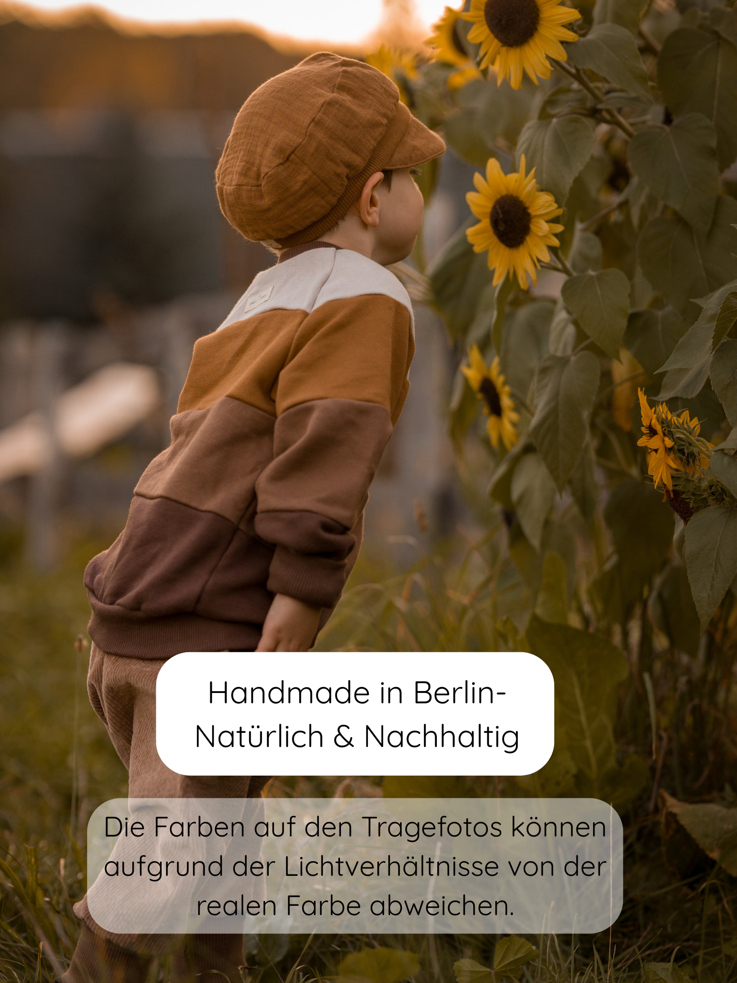 Kleinkind in Weizenfarbener Knickerbocker Breitcord Stretch, passend für kühlere Tage, mit bequemer Passform und wachsendem Bund, steht bei Sonnenblumen im goldenen Licht. Handgemacht in Berlin.