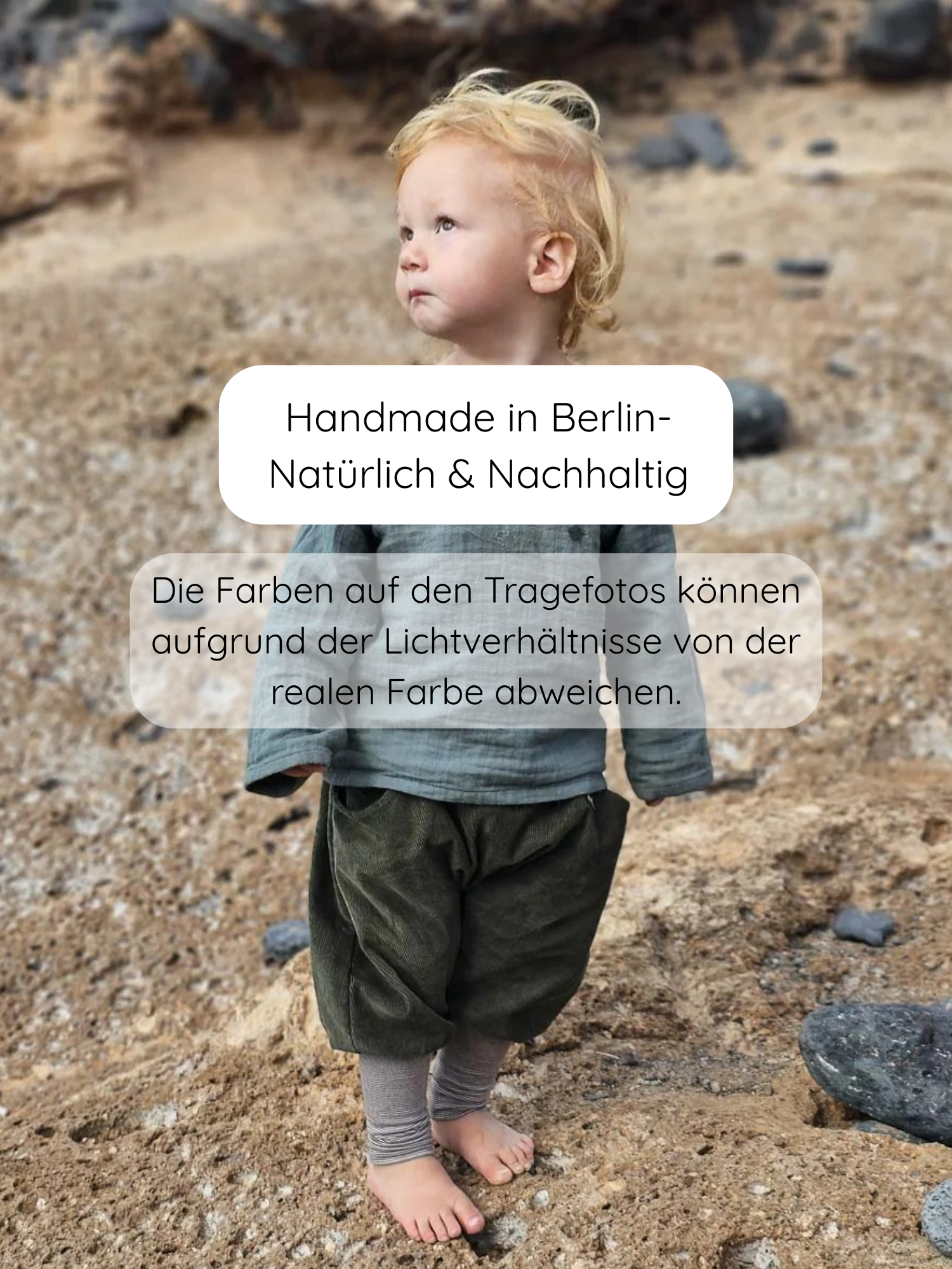 Ein Kleinkind am Strand trägt Knickerbocker Feincord Ringel - Avocado, eine handgemachte, bequeme Hose mit elastischem Ringelbündchen, ideal für Bewegungsfreiheit und Komfort.