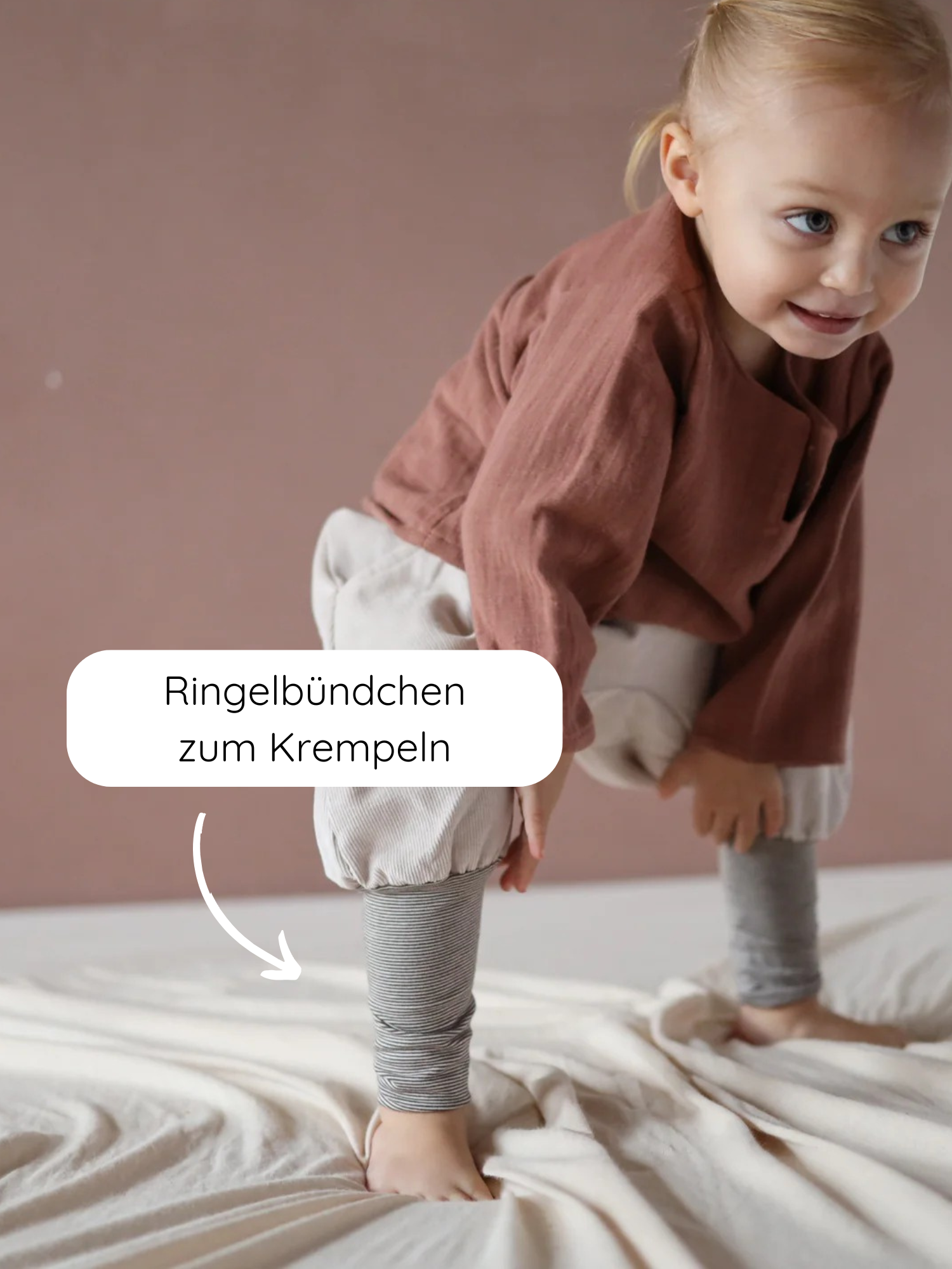 Kleinkind trägt Knickerbocker Feincord Ringel - Sand, aus weichem Cord, mit gestreiften, krempelbaren Bündchen an den Knöcheln. Perfekt für aktive Kinder, handgemacht in Berlin und bietet Bewegungsfreiheit.