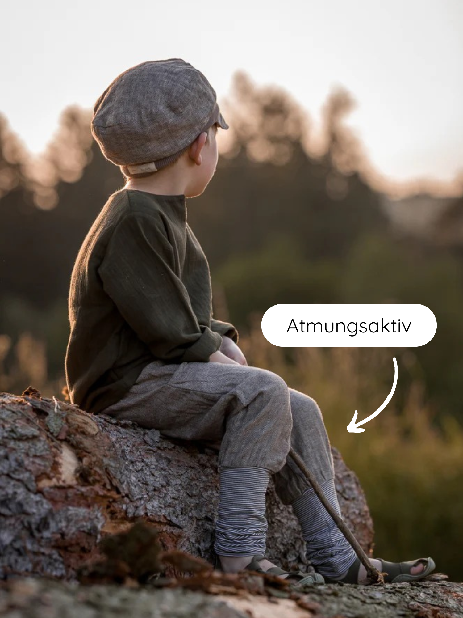 Knickerbocker Fischgrat: Kind sitzt auf Baumstamm, trägt atmungsaktive, locker sitzende Hose aus Leinen-Baumwoll-Mix, ideal für Abenteuer und bequem mitwachsend. Perfekt für den Alltag und kühlere Tage.