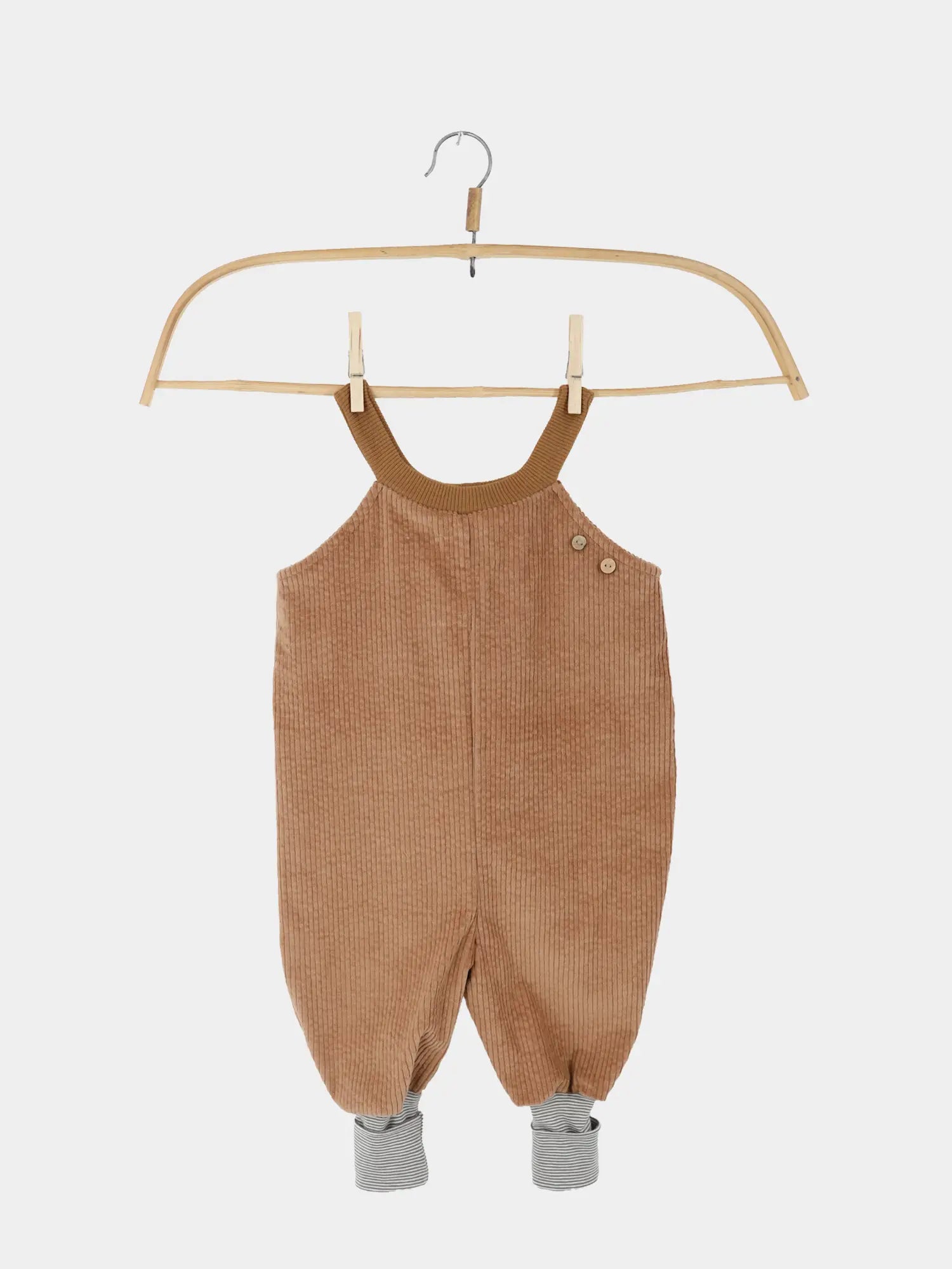 Schlupflatzhose Breitcord - Weizen: Weiche, tanfarbene Cord-Latzhose mit dekorativen Knöpfen, grauweiß gestreiften Bündchen und verstellbaren Trägern, ideal für Kinder, handgenäht in Berlin aus schadstoffgeprüften Materialien.