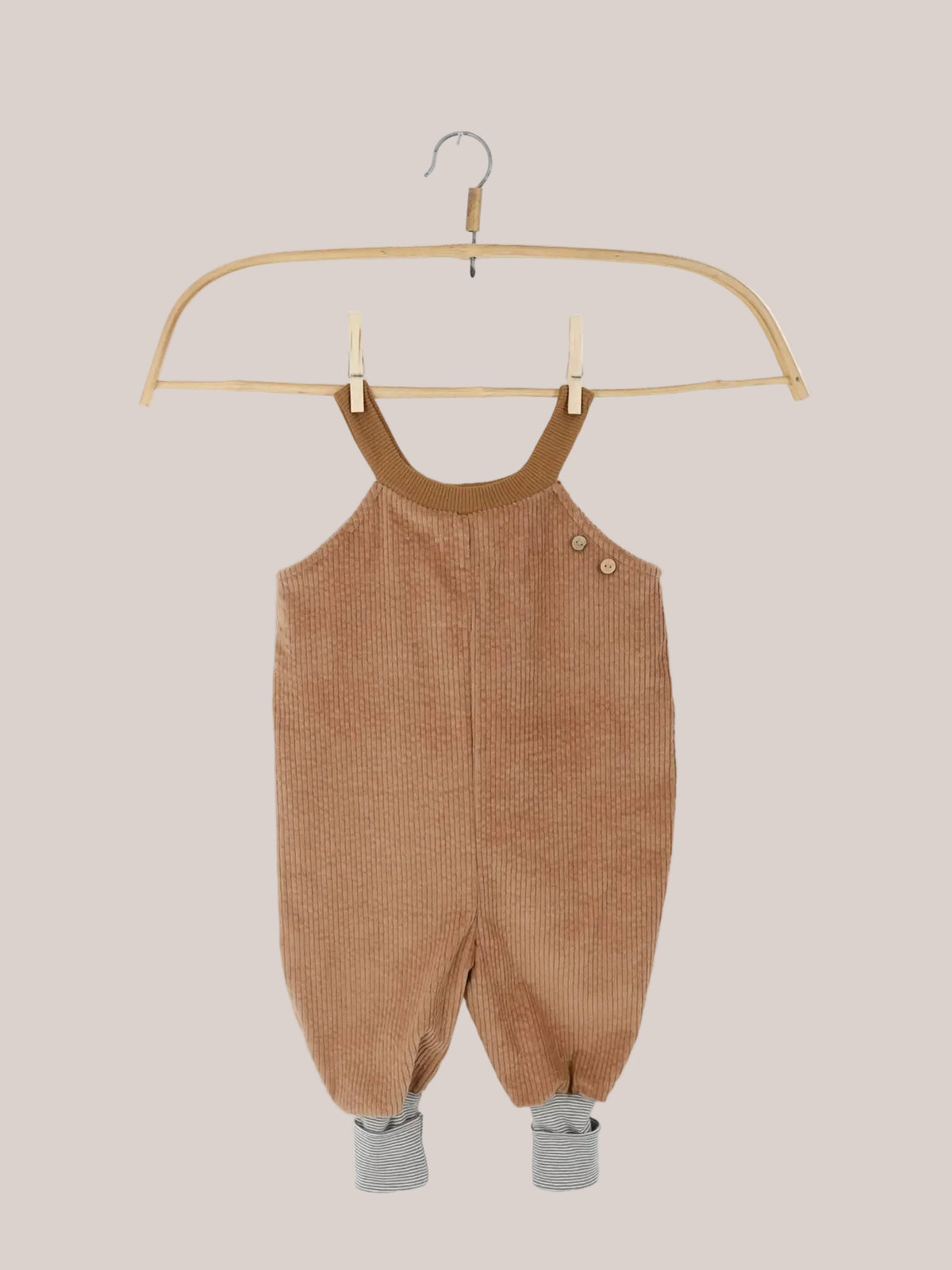 Schlupflatzhose Breitcord - Weizen: Weiche, tanfarbene Cord-Latzhose mit dekorativen Knöpfen, grauweiß gestreiften Bündchen und verstellbaren Trägern, ideal für Kinder, handgenäht in Berlin aus schadstoffgeprüften Materialien.