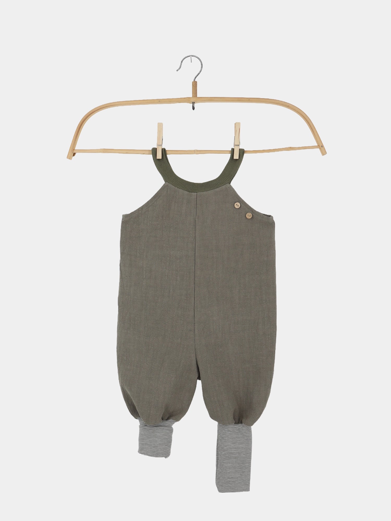 Schlupflatzhose Leinen - Oliv: Einteiliges Baby-Kleinkind-Romper in olivgrün mit geripptem Ausschnitt, zwei Holzknöpfen an der Schulter und grau-weiß gestreiften Bündchen an den Knöcheln.
