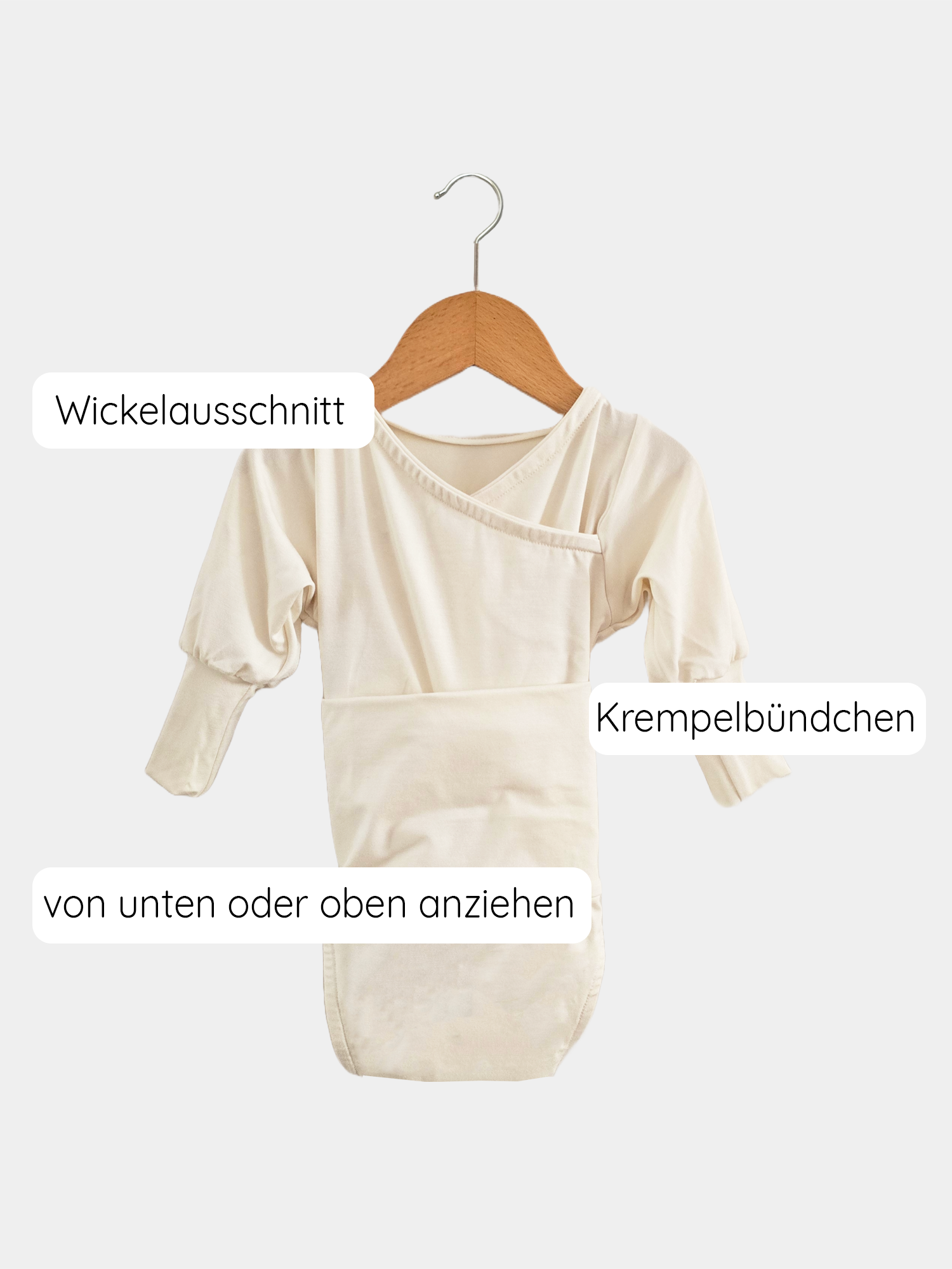 Loopbody Tencel - mitwachsender Babybody - Natur: Weißer, langärmeliger Body auf einem Kleiderbügel. Der Body zeigt einen bequemen Wickelstil, ideal für Babys, mit atmungsaktivem, hautfreundlichem Tencel-Material.