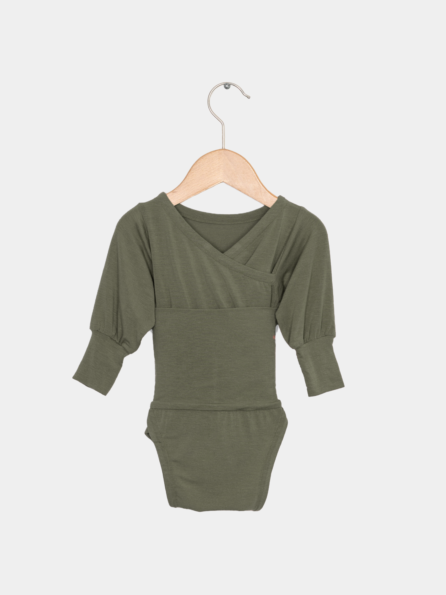 Loopbody Kaschmir-Mix - mitwachsender Babybody - Avocado auf einem Holzbügel, betont die weiche, knopflose Konstruktion aus Kaschmir-Mix für Babys. Ideale Baby Geschenke.