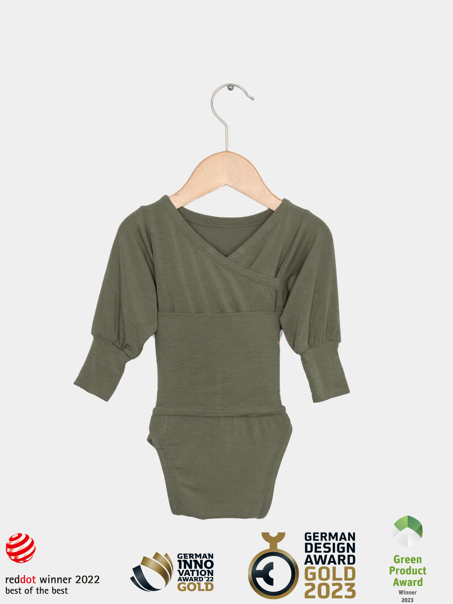 Loopbody Kaschmir-Mix - Avocado: Langarm-Body mit Wickelausschnitt, gepufften Ärmeln und Druckknopfverschluss, aus weichem, atmungsaktivem Kaschmir-Mix, an Holzkleiderbügel hängend, mit zahlreichen Design- und Innovationspreisen ausgezeichnet.