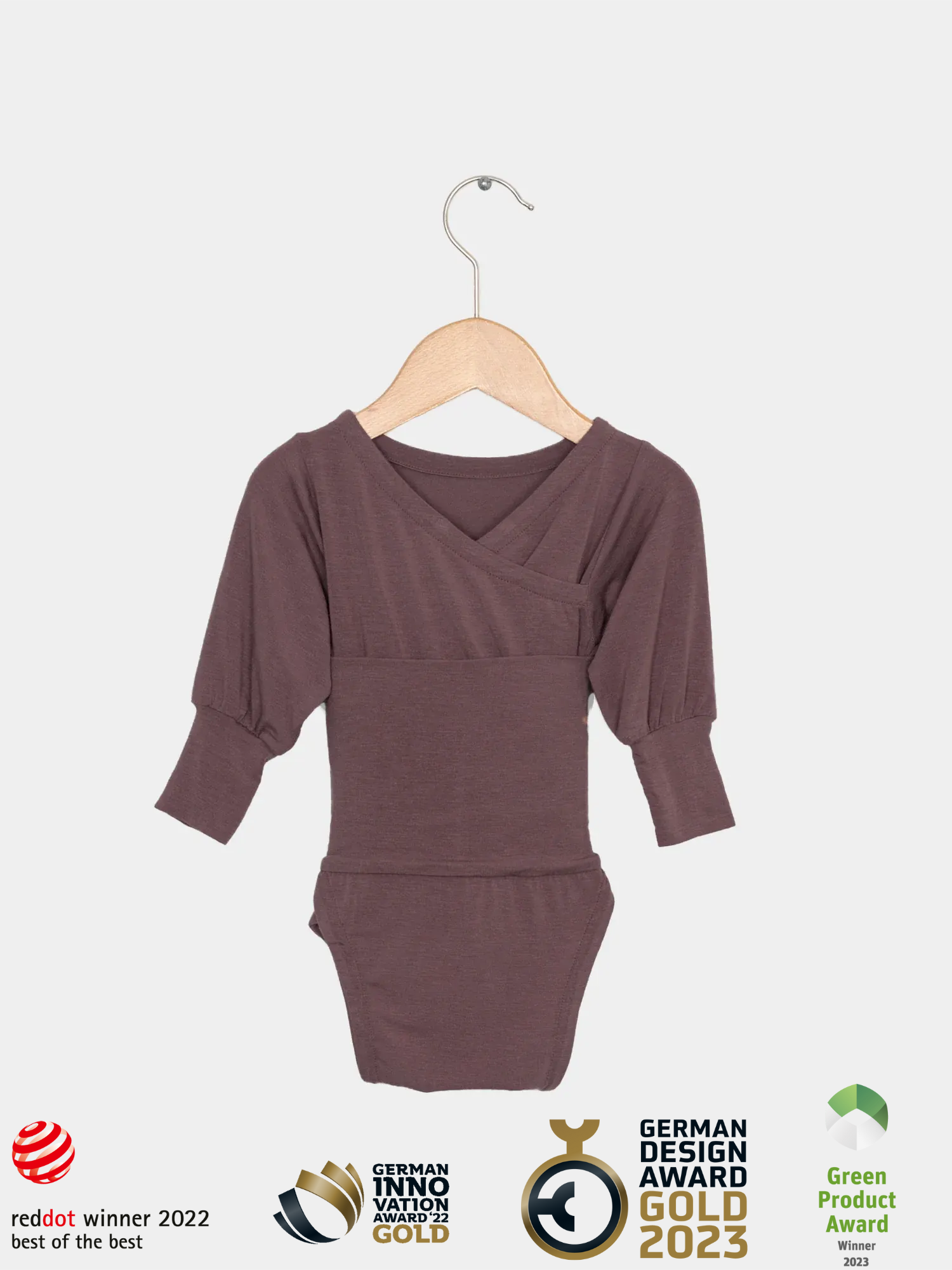 Loopbody Kaschmir-Mix - Malve: Langärmeliger, kimono-inspirierter Babybody mit leicht gepufften Ärmeln, präsentiert auf Holzbügel. Mehrfach preisgekröntes Design, nachhaltig gefertigt, bietet Komfort und wächst mit.