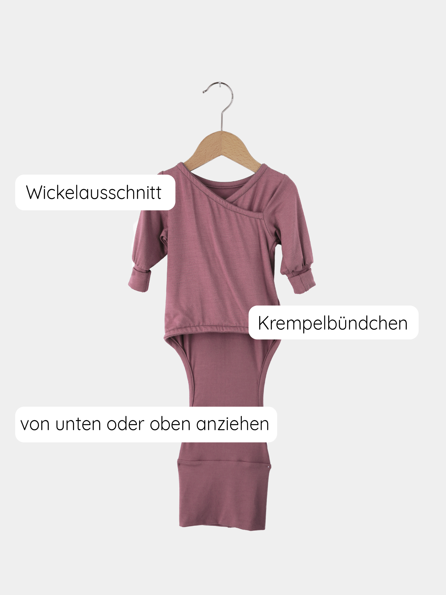 Der Loopbody Tencel - mitwachsender Babybody - Beere hängt auf einem Kleiderbügel, zeigt sein weiches, atmungsaktives Design und symbolisiert Komfort und Funktionalität für Babys.