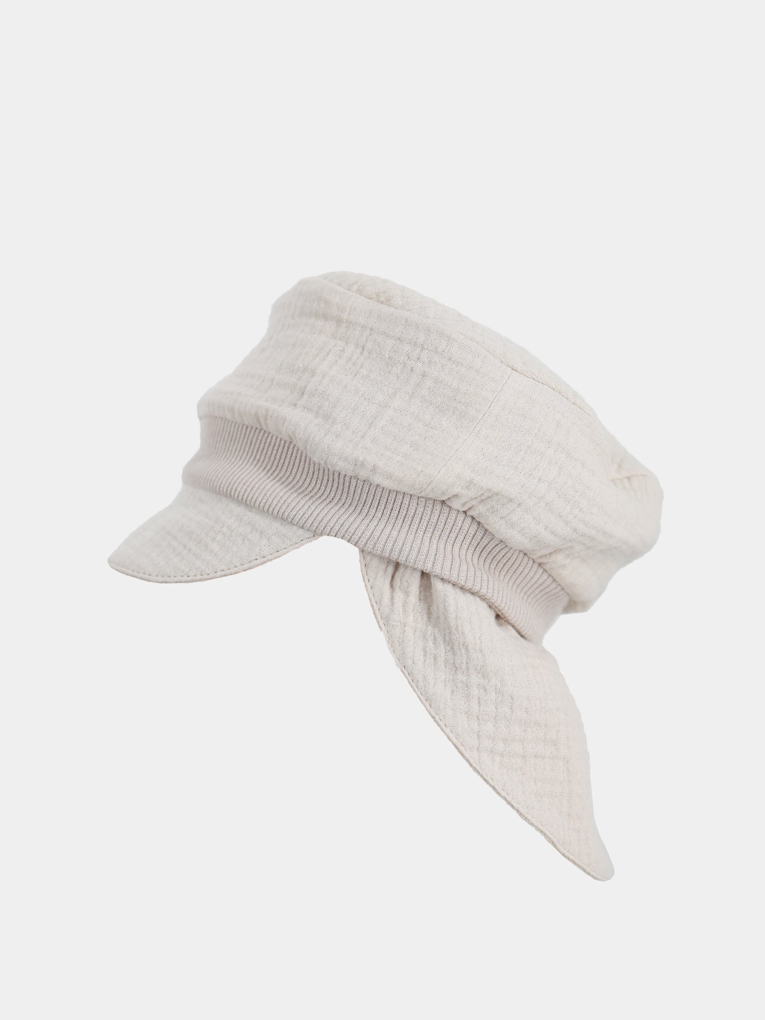 Die Michelmütze Bio-Musselin mit Nackenschutz - Sand ist eine leichte, beige Mütze im Baker-Boy-Stil mit kurzem Schirm und lockeren, schalartigen Paneelen, ideal für sommerlichen Sonnenschutz.