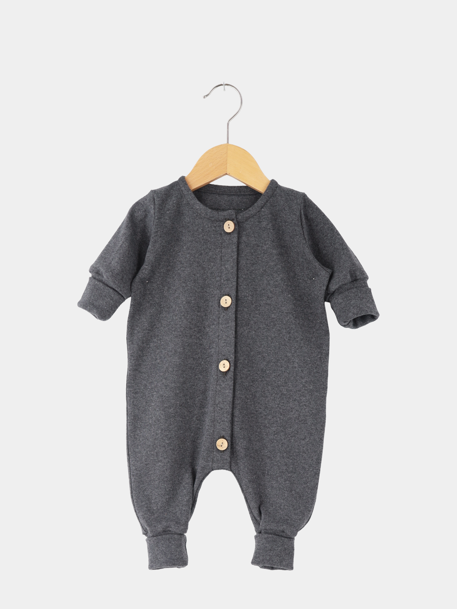 Mini Overall Feinstrick - Ruß Meliert: Dunkelgrauer langärmeliger Babystrampler mit Rundhalsausschnitt, Manschetten und vier hellen Holzknöpfen vorne, aus weichem, atmungsaktivem Feinstrick-Jersey, auf einfachem Holzkleiderbügel hängend.