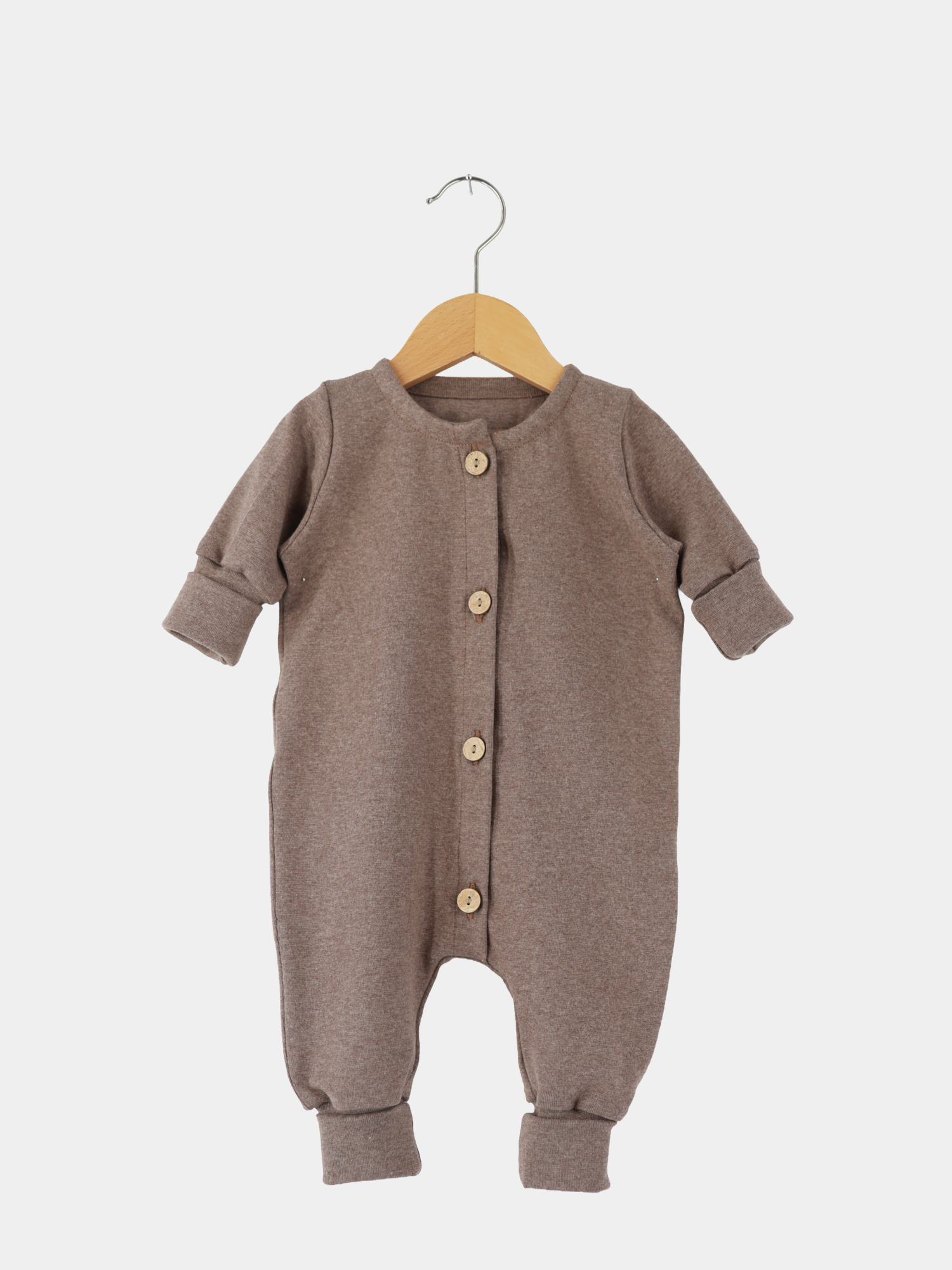 Mini Overall Feinstrick - Praline Meliert: Langarm-Strampler aus braunem Feinstrick-Jersey mit Rundhalsausschnitt, Holzknöpfen und umklappbaren Bündchen, auf Holzkleiderbügel präsentiert.