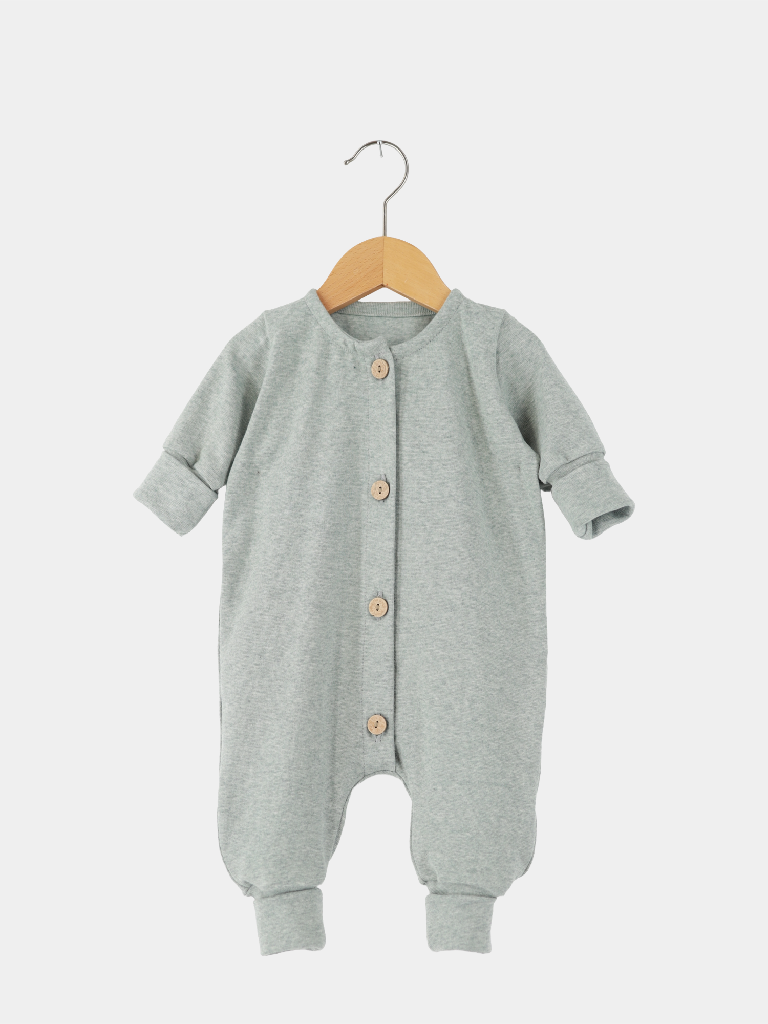 Mini Overall Feinstrick - Mint Meliert: Langarm-Babystrampler in meliertem Feinstrick-Jersey, mit Knopfleiste, auf Holzbügel hängend. Bequeme Bündchen, leicht anzuziehen, ideal für Spiel- oder Schlafzeiten.